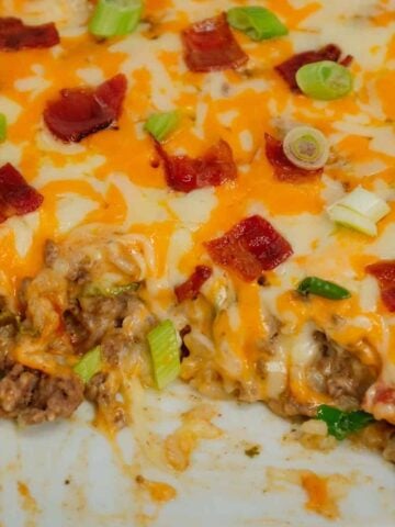 Cheesy Ranch Ground Beef and Rice Casserole is a hearty dinner recipe loaded with ground beef, instant rice, bacon, cheddar soup, milk, ranch dressing mix, chopped green onions and shredded cheese.