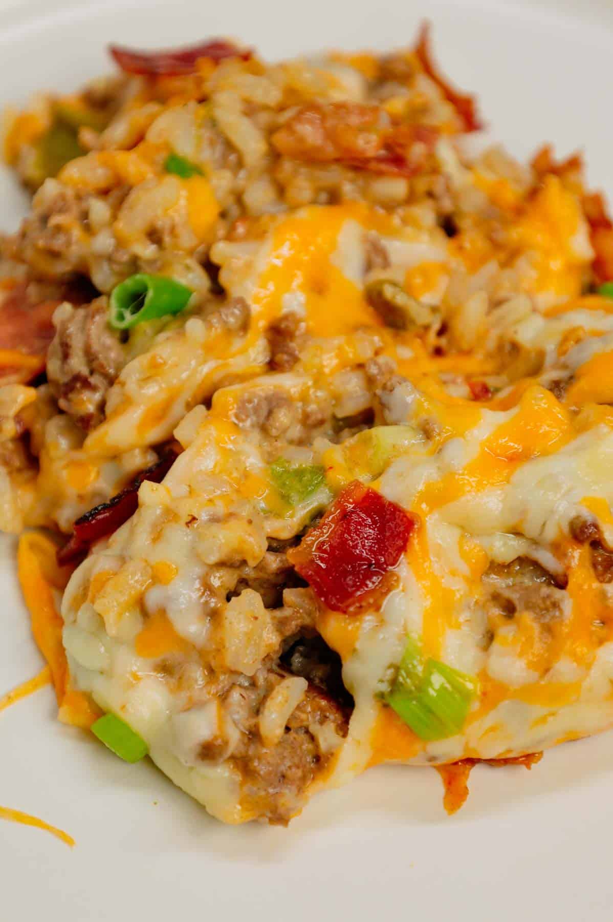 Cheesy Ranch Ground Beef and Rice Casserole is a hearty dinner recipe loaded with ground beef, instant rice, bacon, cheddar soup, milk, ranch dressing mix, chopped green onions and shredded cheese.