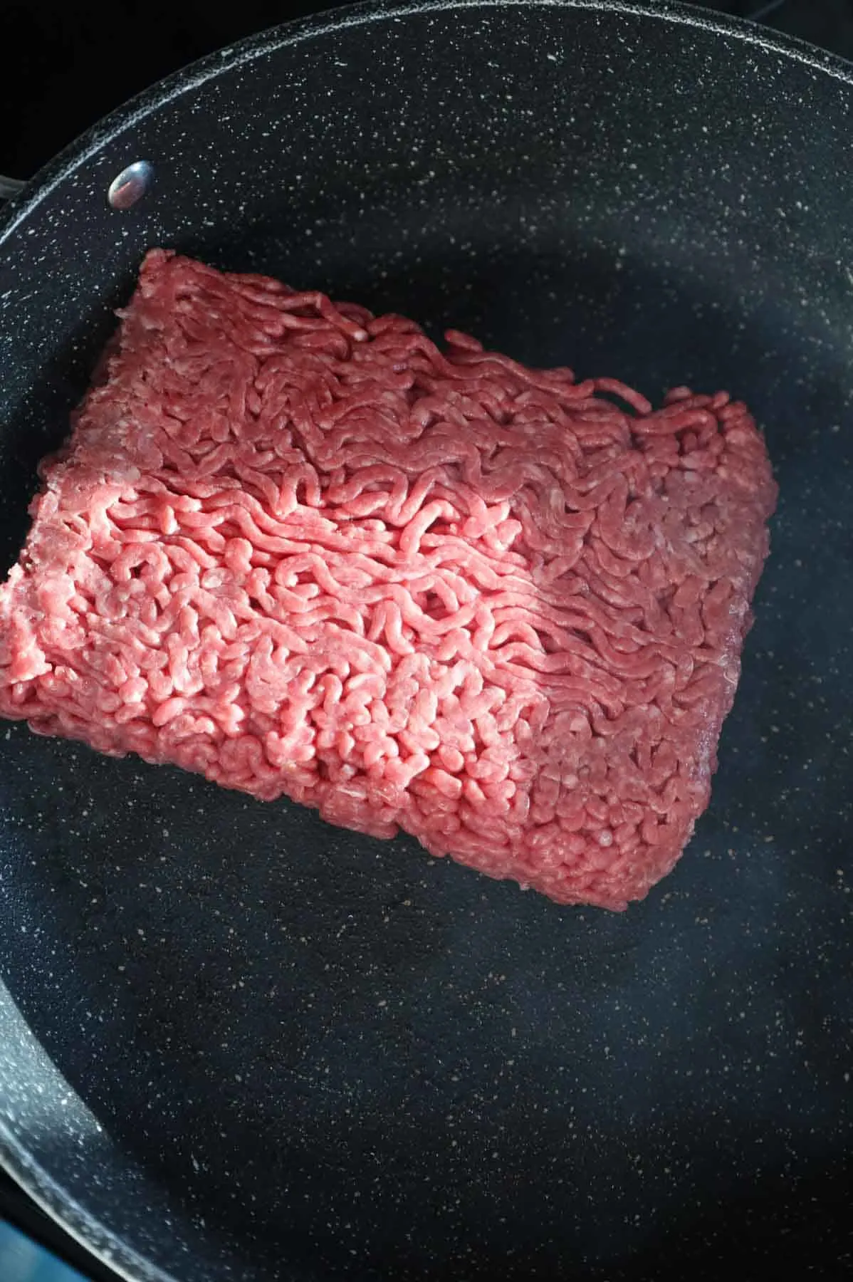 raw ground beef in a skillet