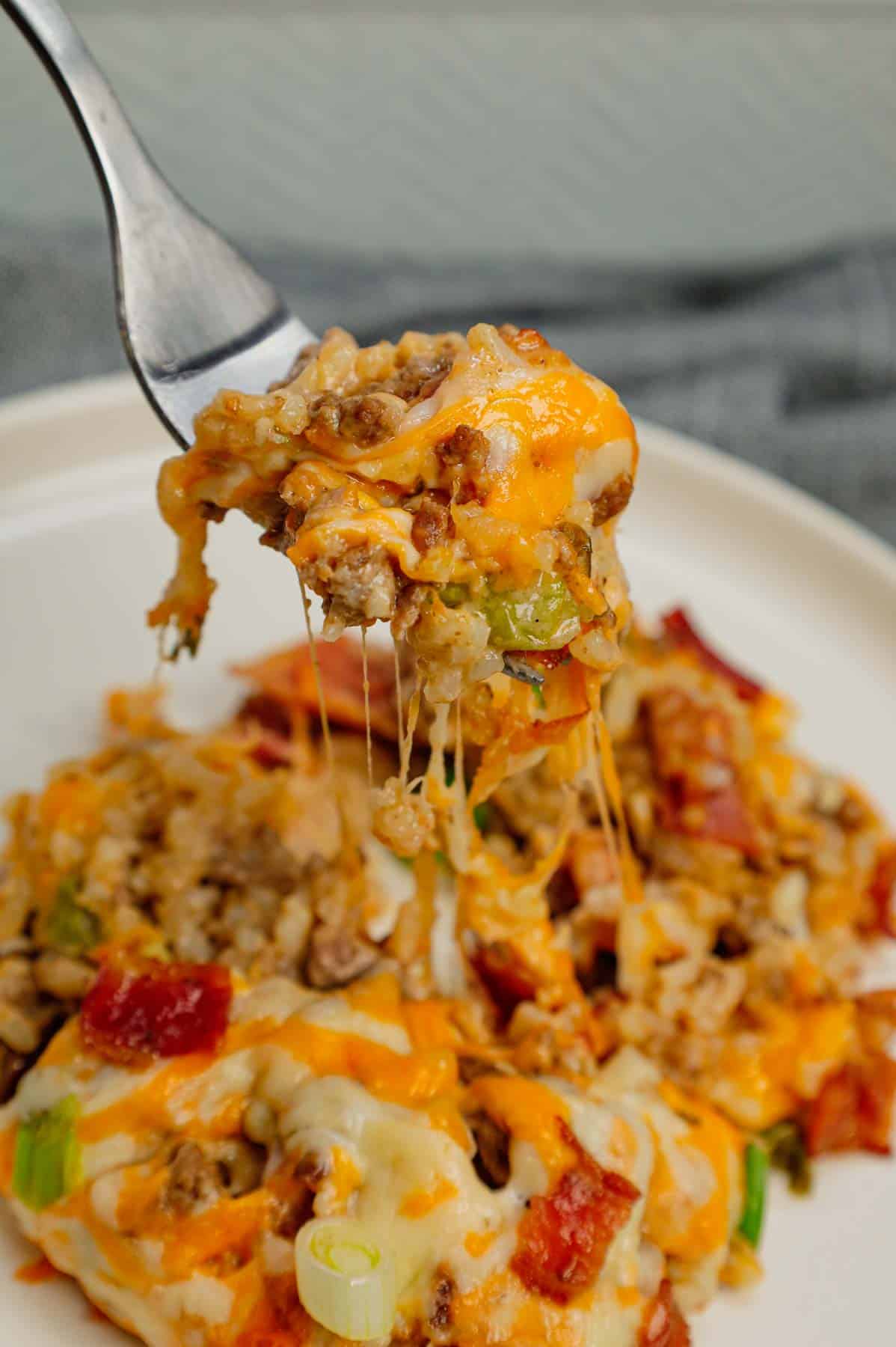 Cheesy Ranch Ground Beef and Rice Casserole is a hearty dinner recipe loaded with ground beef, instant rice, bacon, cheddar soup, milk, ranch dressing mix, chopped green onions and shredded cheese.