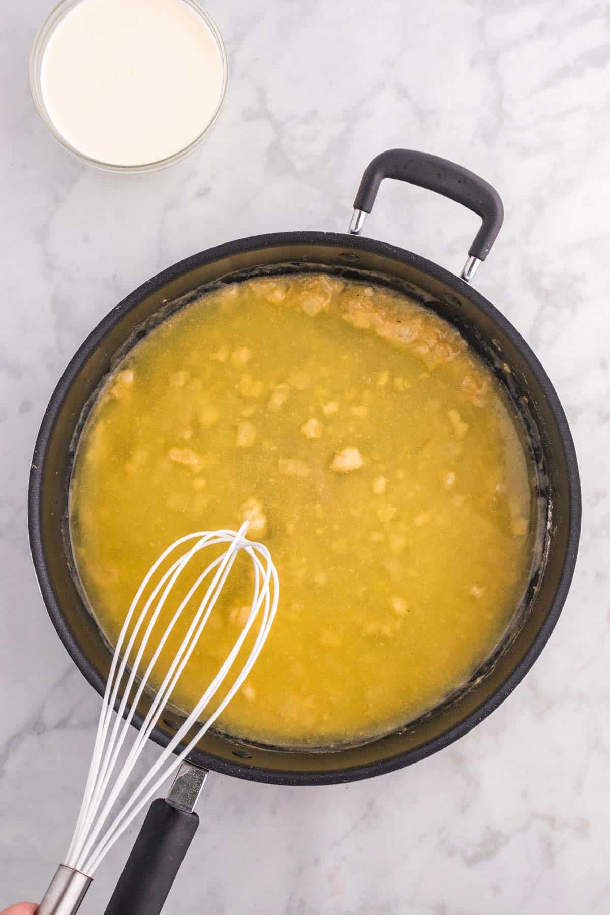 chicken broth added to roux in a saucepan