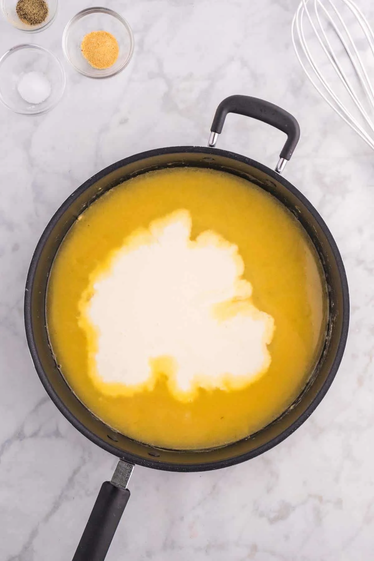 heavy cream added to broth mixture in a saucepan
