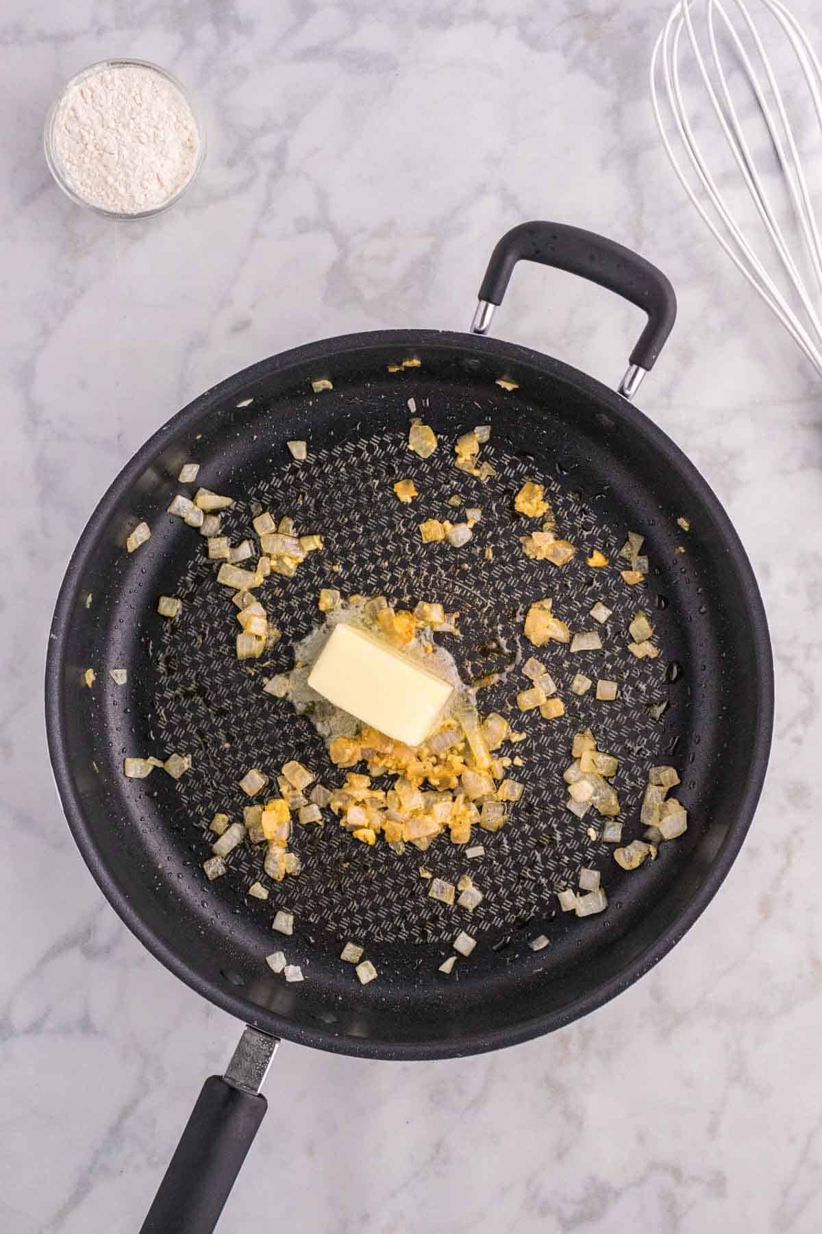butter added to skillet with cooked onions and minced garlic