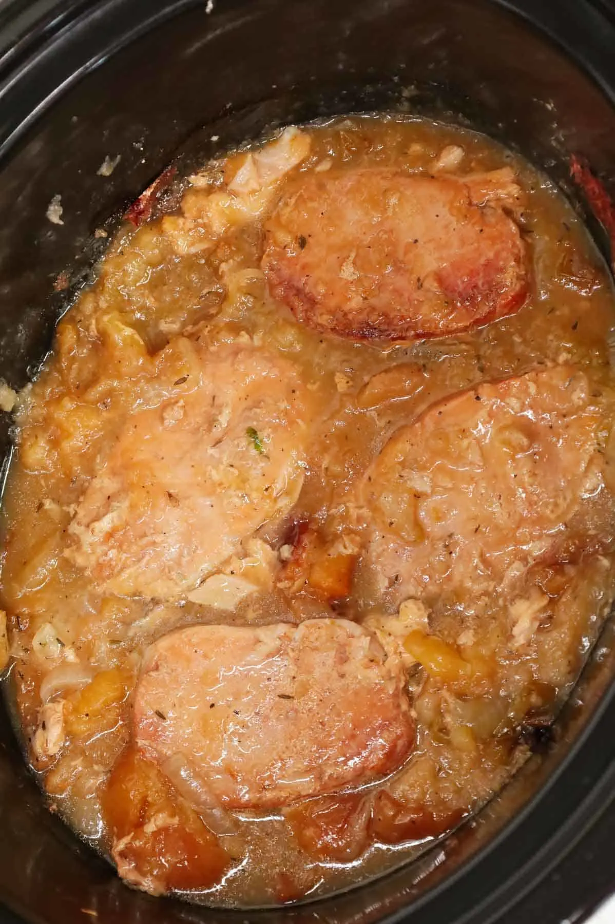 Crock Pot Apple Pork Chops are an easy slow cooker dinner recipe made with boneless pork chops, green apples, red apples and sliced onions.