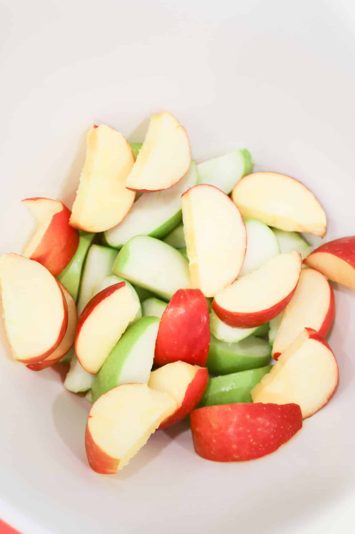 green and red apple slices in a bowl
