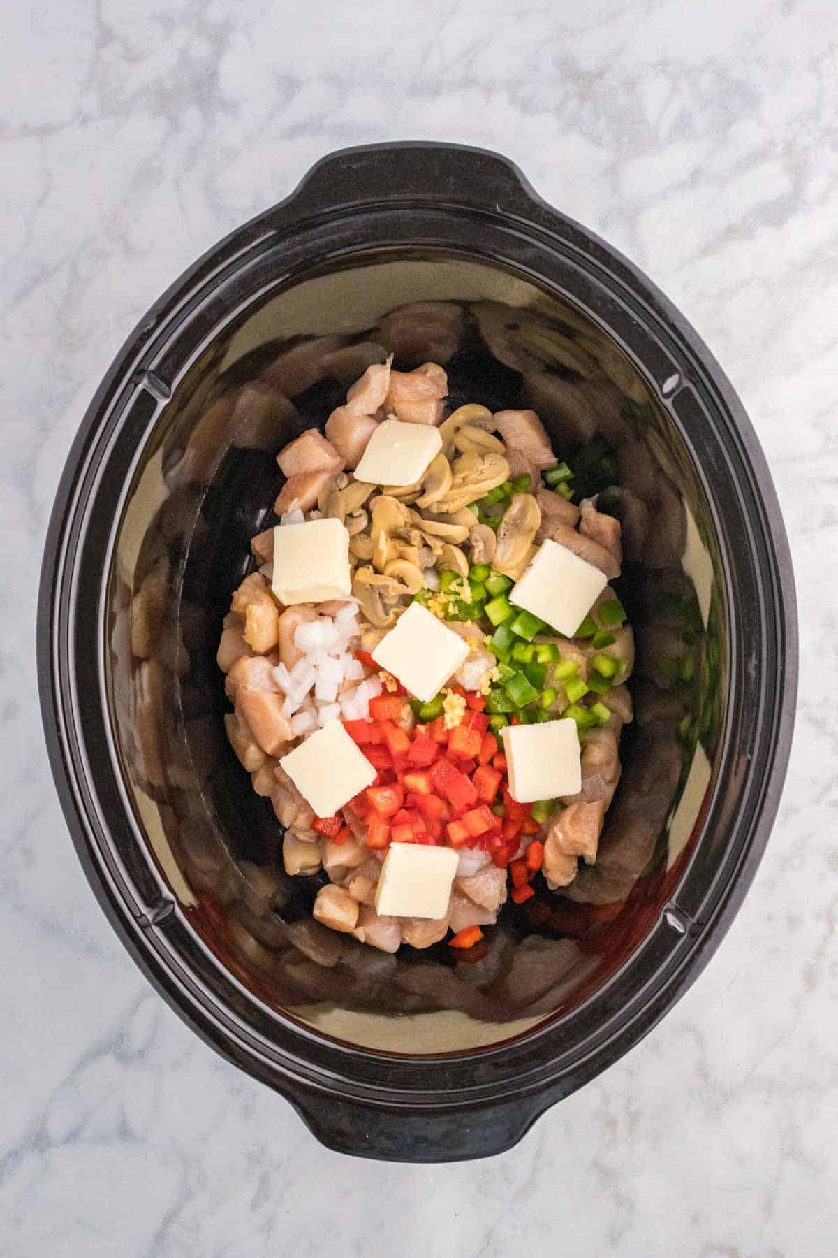 butter squares, chopped veggies and chicken chunks in a slow cooker