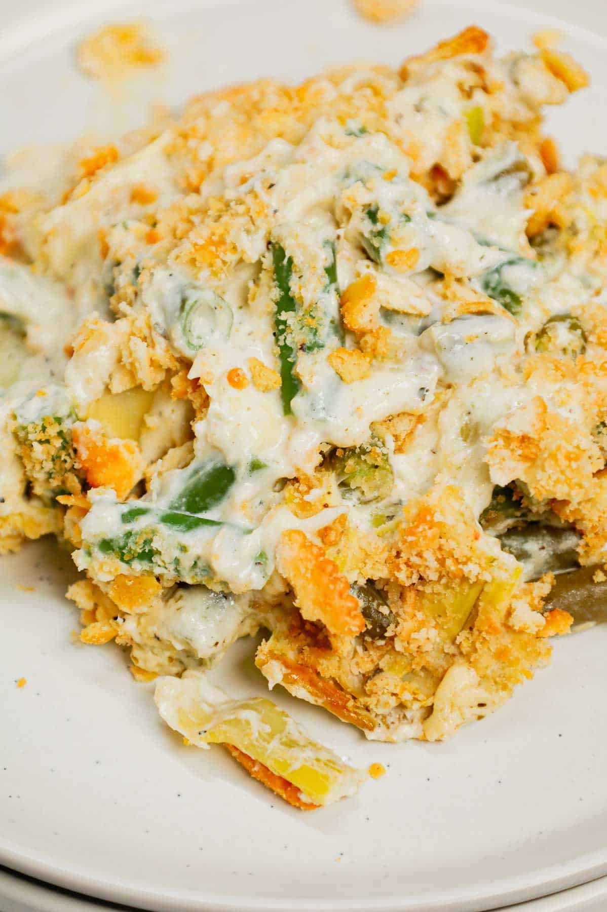 Green Bean Artichoke Casserole is a delicious holiday side dish recipe loaded with cut green beans, artichoke hears, cream cheese, sour cream, mozzarella cheese and parmesan cheese with a crushed Ritz cracker topping.