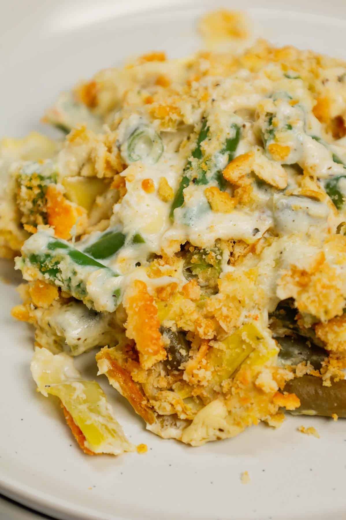 Green Bean Artichoke Casserole is a delicious holiday side dish recipe loaded with cut green beans, artichoke hears, cream cheese, sour cream, mozzarella cheese and parmesan cheese with a crushed Ritz cracker topping.