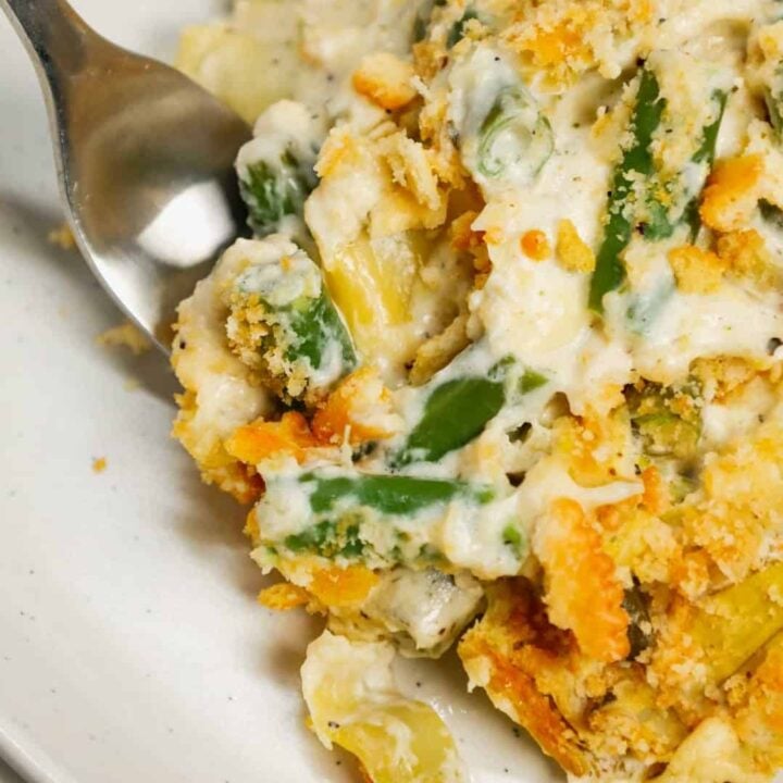 Green Bean Artichoke Casserole is a delicious holiday side dish recipe loaded with cut green beans, artichoke hears, cream cheese, sour cream, mozzarella cheese and parmesan cheese with a crushed Ritz cracker topping.