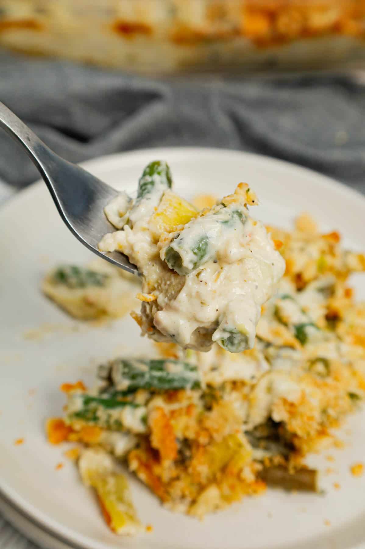 Green Bean Artichoke Casserole is a delicious holiday side dish recipe loaded with cut green beans, artichoke hears, cream cheese, sour cream, mozzarella cheese and parmesan cheese with a crushed Ritz cracker topping.