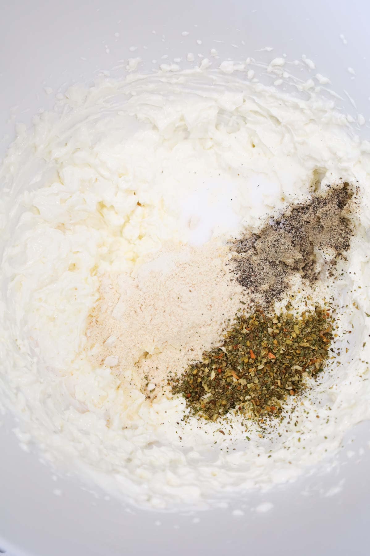 spices added to bowl with cream cheese and sour cream mixture