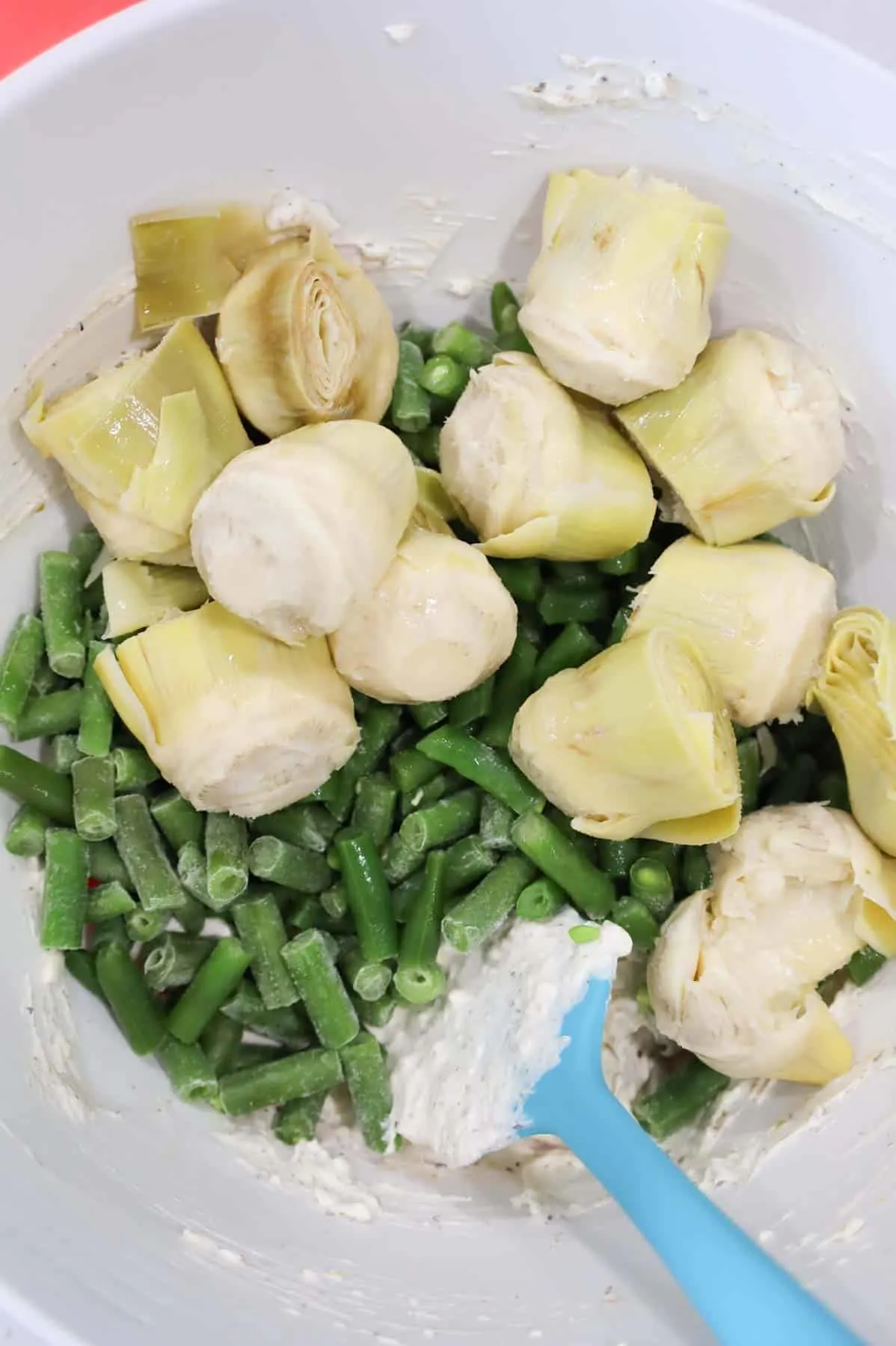 artichoke hearts and cut green beans added to bowl with sour cream and cream cheese mixture