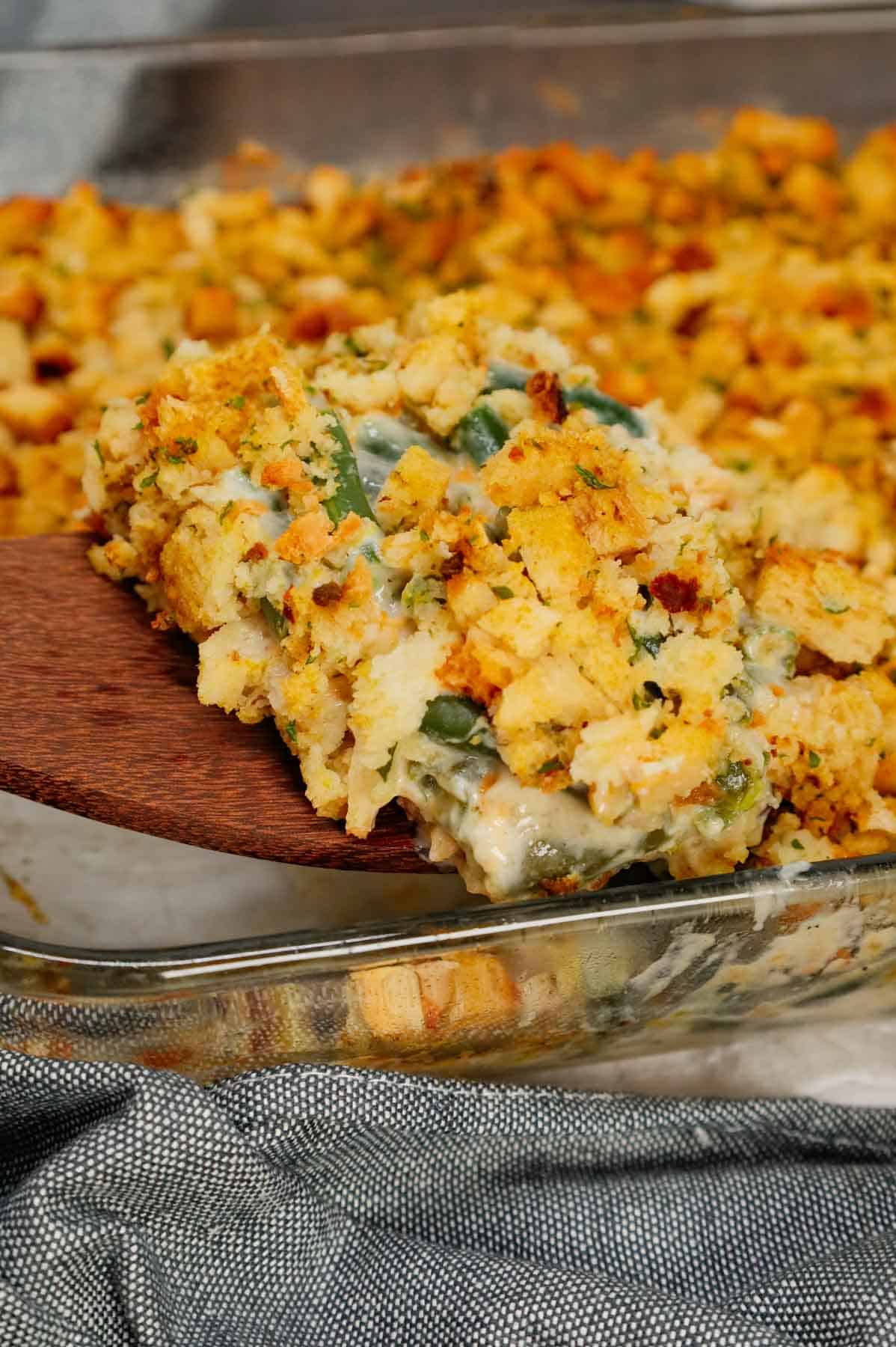 Green Bean Stuffing Casserole is a tasty side dish recipe made with frozen cut green beans, cream of mushroom soup, sour cream, French's crispy fried onions, shredded cheddar cheese, chicken broth and topped with stove top stuffing mix.