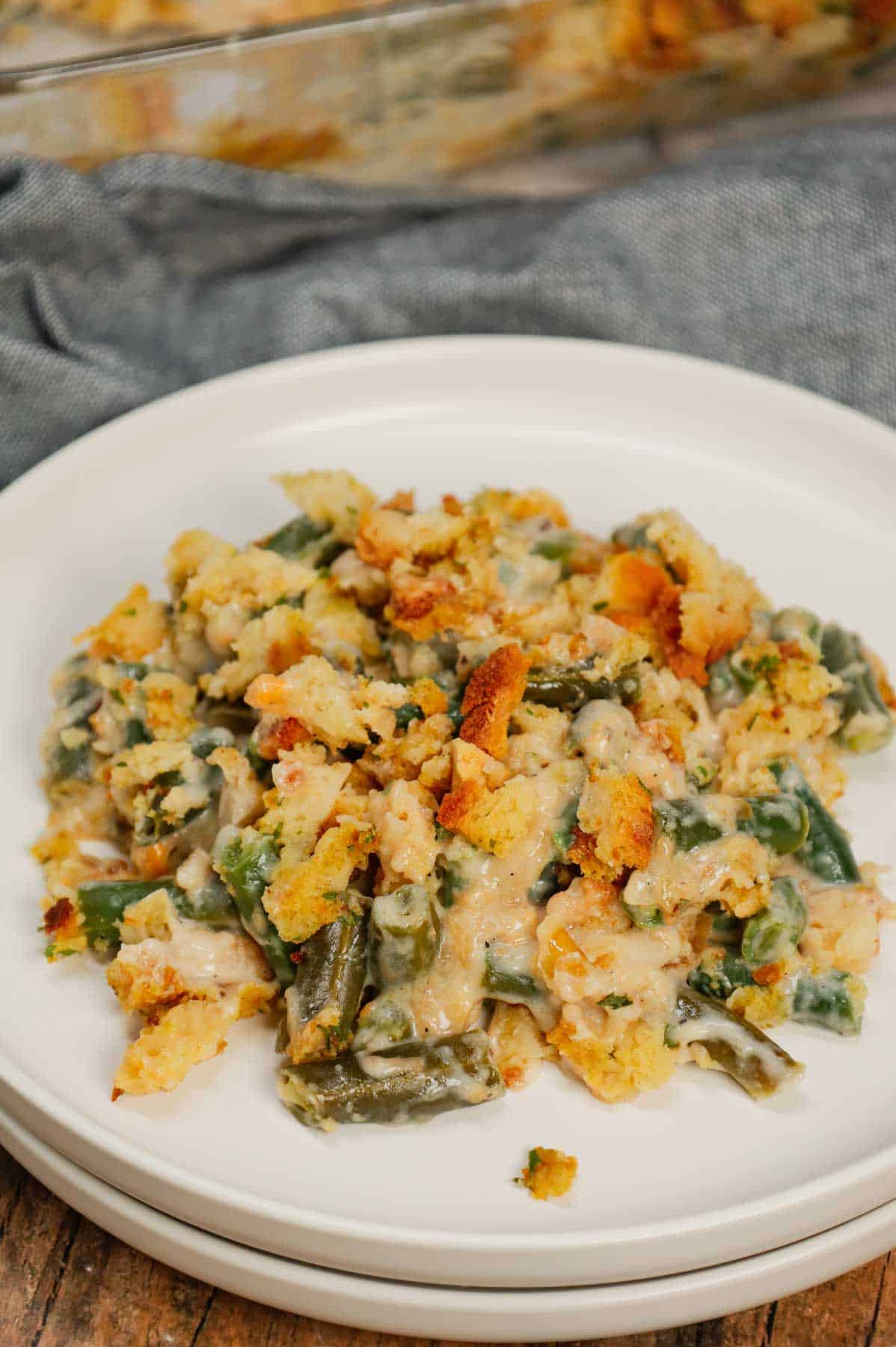 Green Bean Stuffing Casserole is a tasty side dish recipe made with frozen cut green beans, cream of mushroom soup, sour cream, French's crispy fried onions, shredded cheddar cheese, chicken broth and topped with stove top stuffing mix.