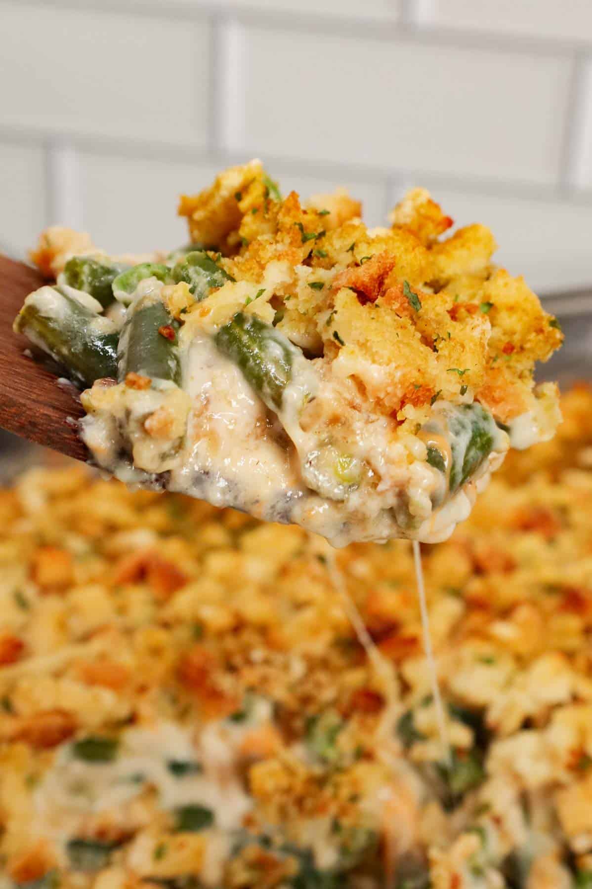 Green Bean Stuffing Casserole is a tasty side dish recipe made with frozen cut green beans, cream of mushroom soup, sour cream, French's crispy fried onions, shredded cheddar cheese, chicken broth and topped with stove top stuffing mix.