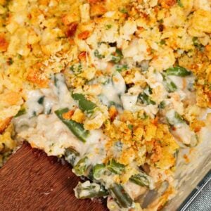 Green Bean Stuffing Casserole is a tasty side dish recipe made with frozen cut green beans, cream of mushroom soup, sour cream, French's crispy fried onions, shredded cheddar cheese, chicken broth and topped with stove top stuffing mix.