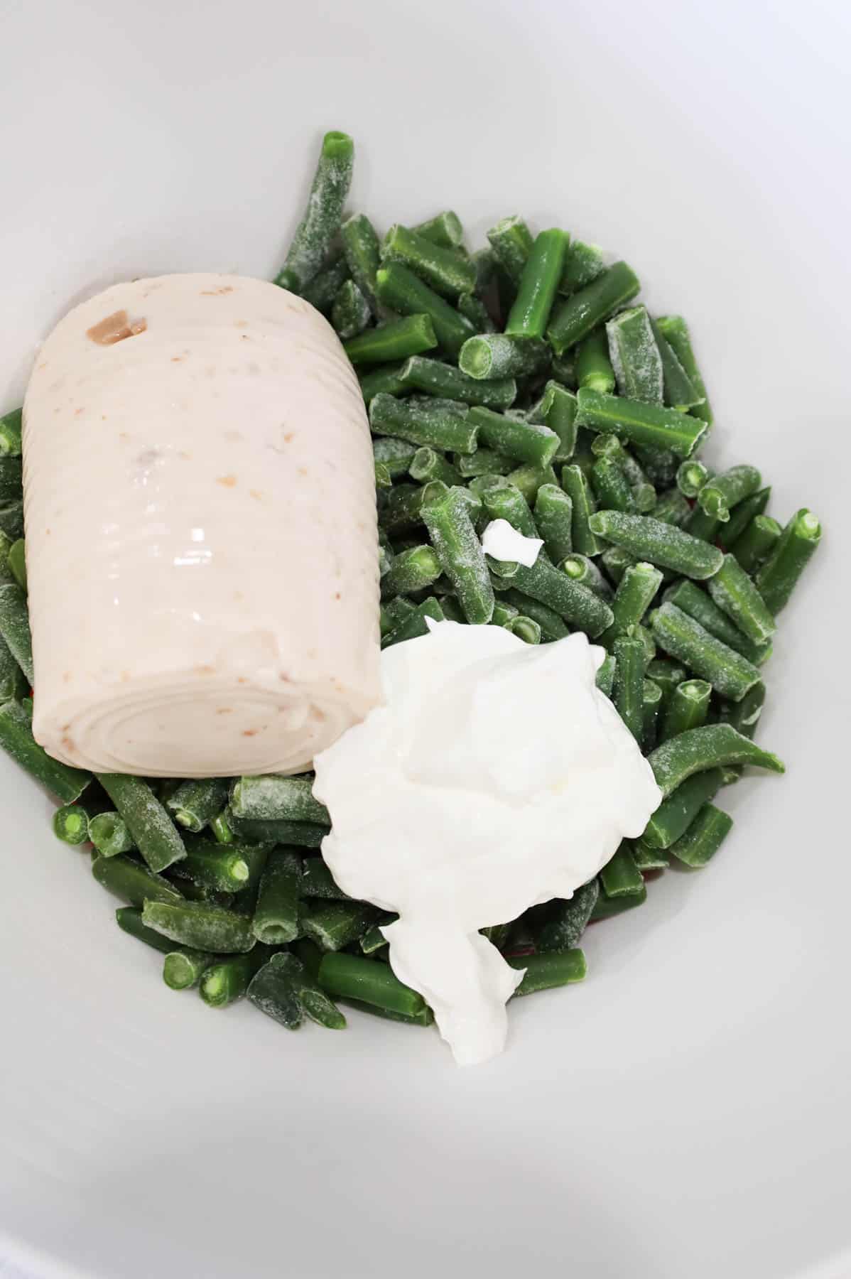 sour cream, cream of mushroom soup and cut green beans in a bowl