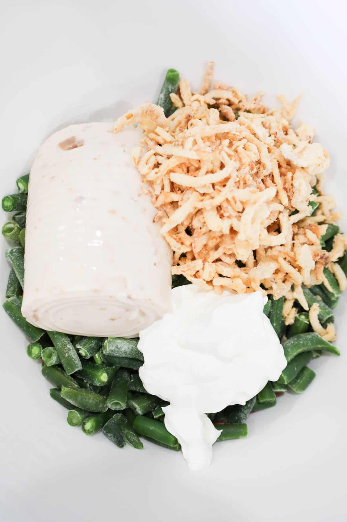 crispy fried onions, sour cream, cream of mushroom soup and cut green beans in a mixing bowl