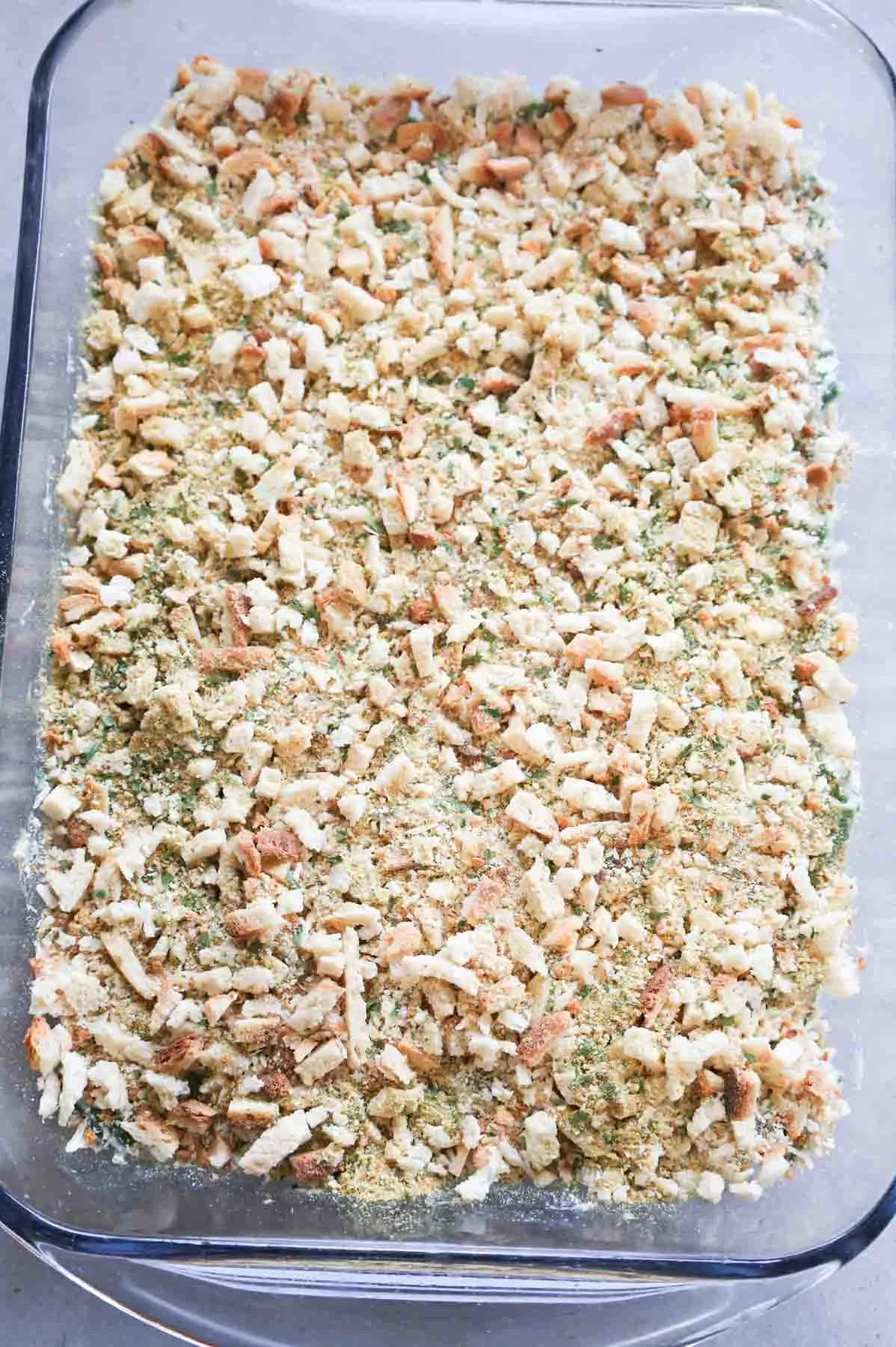 dry stove top stuffing mix on top of green bean casserole in a baking dish
