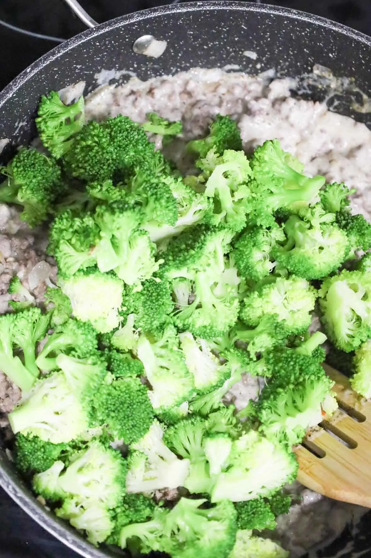 blanched broccoli florets added to skillet with ground beef and alfredo sauce mixture