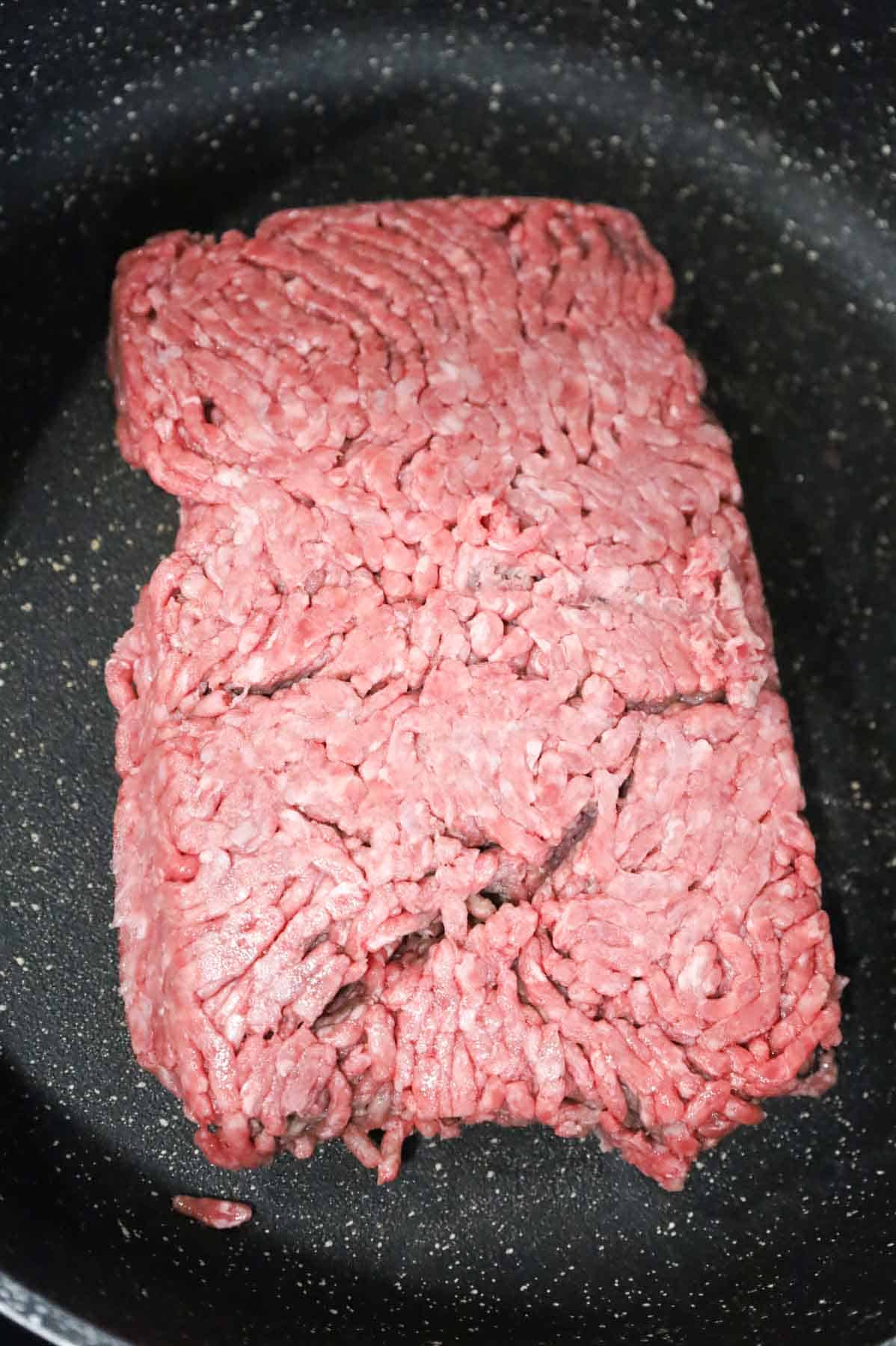 raw ground beef in a skillet