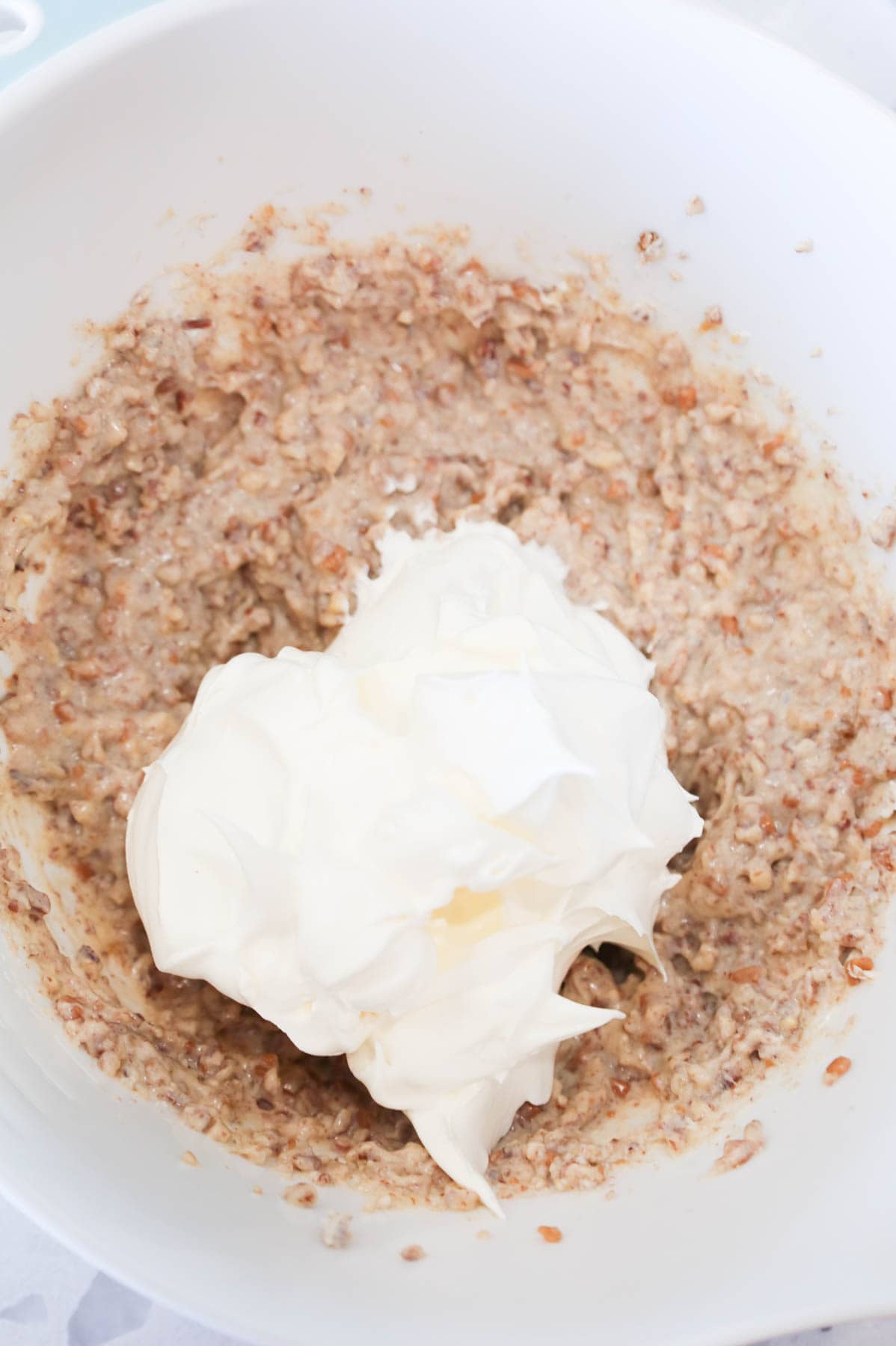 Cool Whip added to mixing bowl with cream cheese pecan mixture