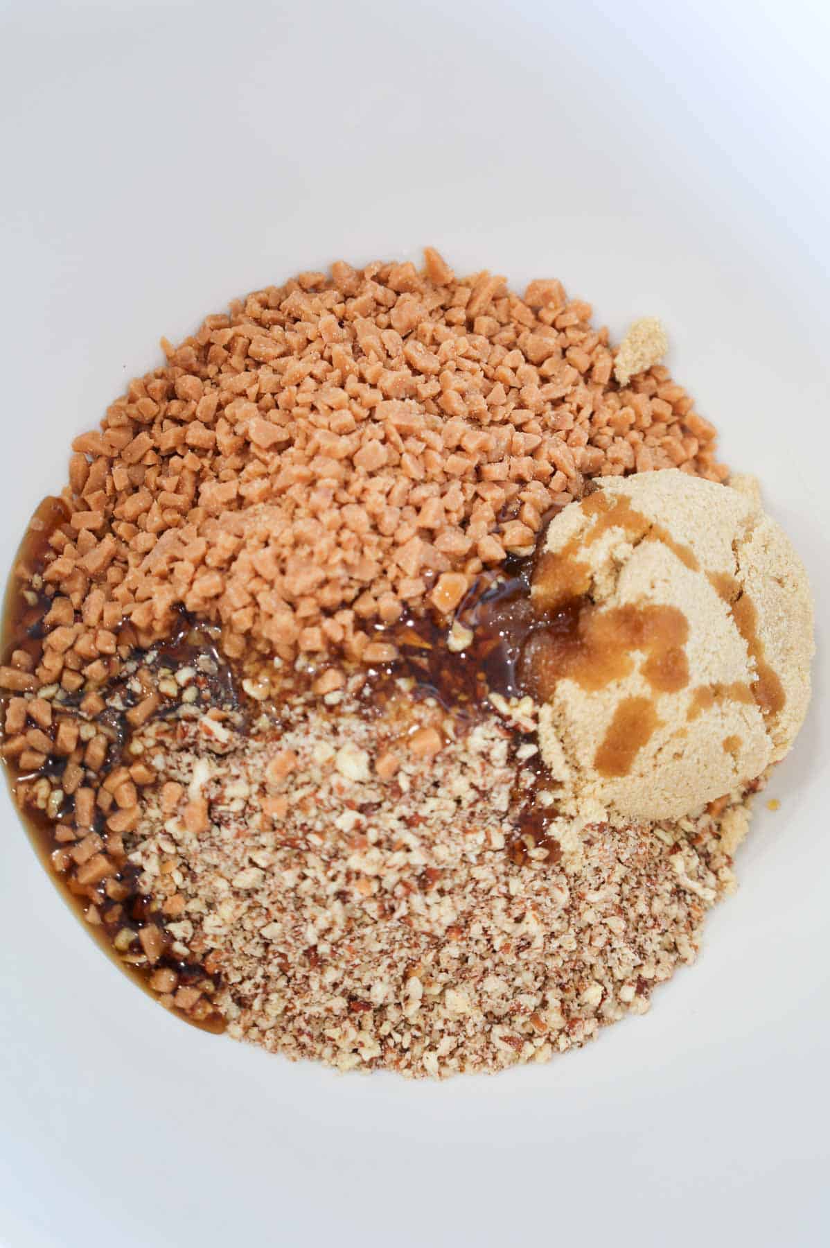 brown sugar, maple syrup, crushed pecans and toffee bits in a mixing bowl