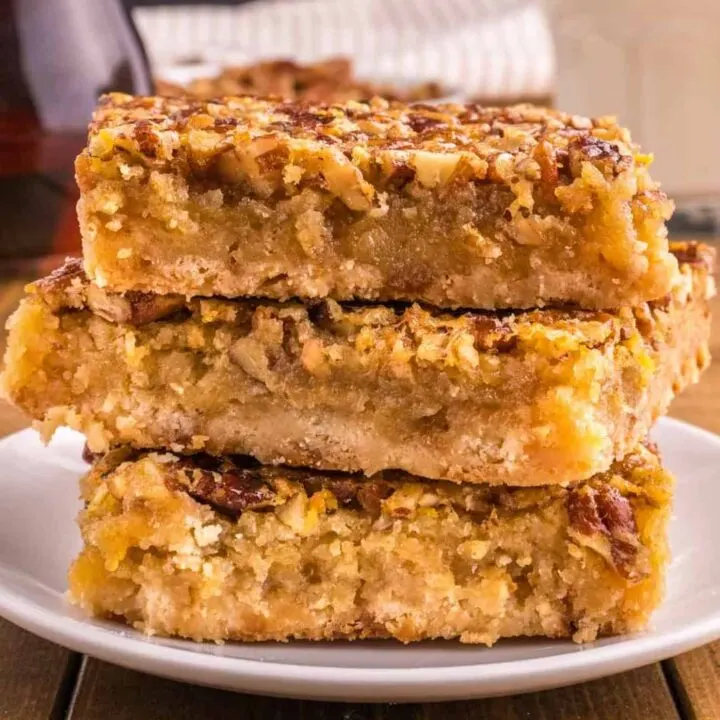Pecan Pie Bars are delicious dessert bars with a shortbread base topped with a pecan pie filling layer made with eggs, maple syrup, corn syrup, brown sugar, butter and chopped pecans.