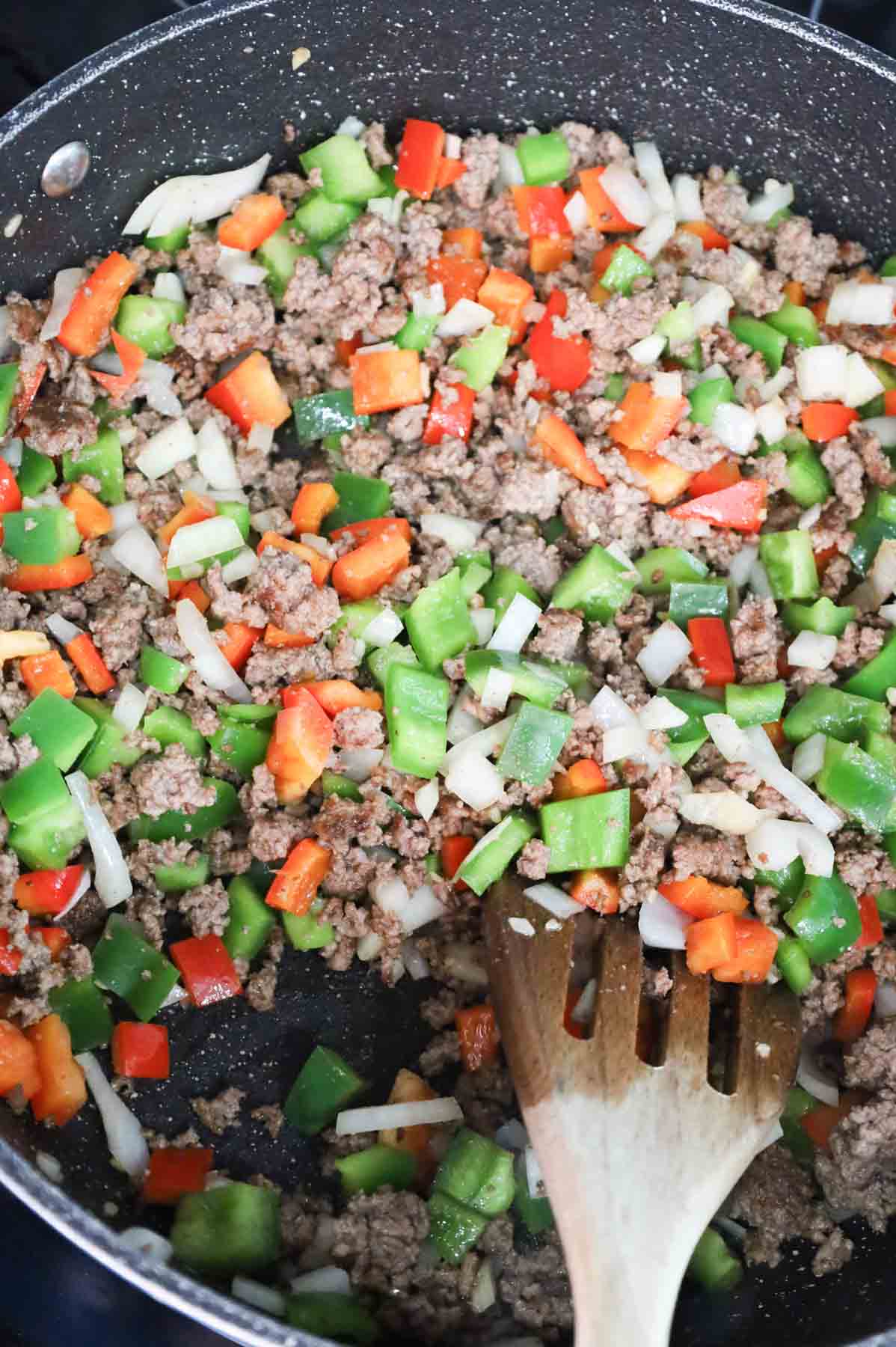 bell peppers, onions and cooked ground beef in a skillet