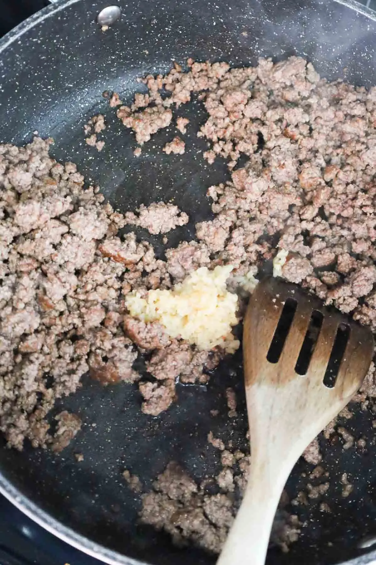 minced garlic added to skillet with cooked ground beef