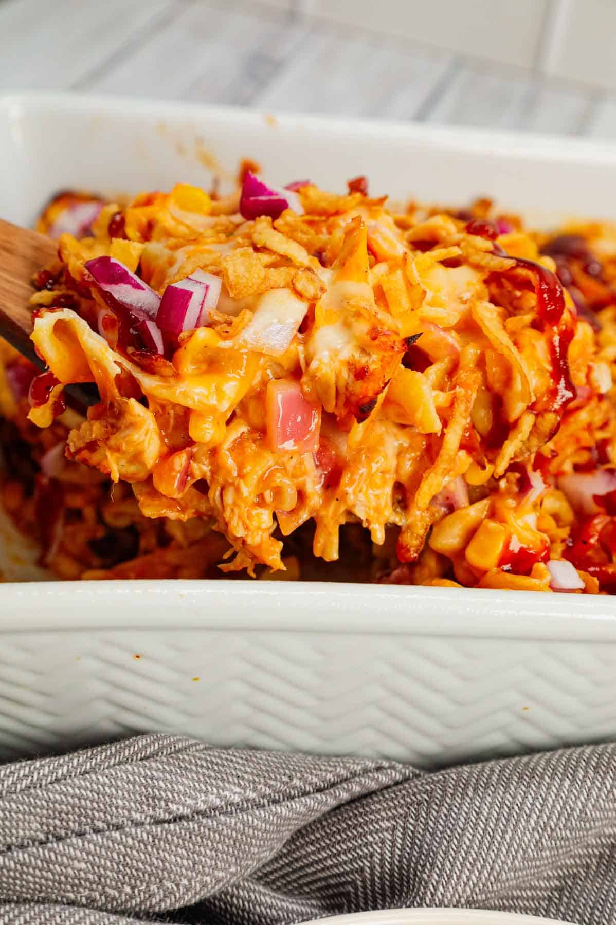 BBQ Chicken Casserole is a hearty dish loaded with egg noodles, shredded rotisserie chicken, diced red onions, corn, cream of chicken soup, barbecue sauce, cheese and French's crispy fried onions.