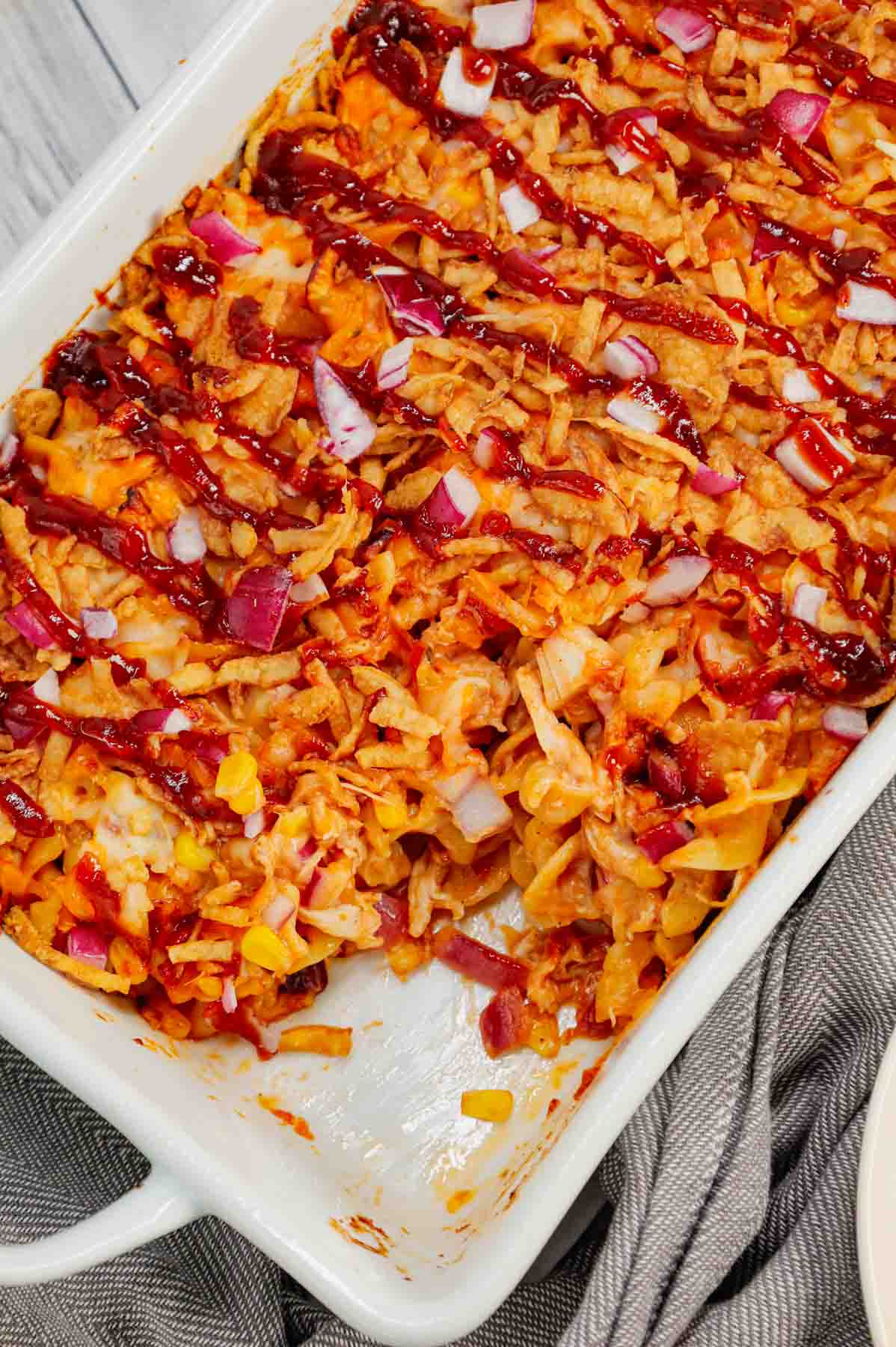 BBQ Chicken Casserole is a hearty dish loaded with egg noodles, shredded rotisserie chicken, diced red onions, corn, cream of chicken soup, barbecue sauce, cheese and French's crispy fried onions.