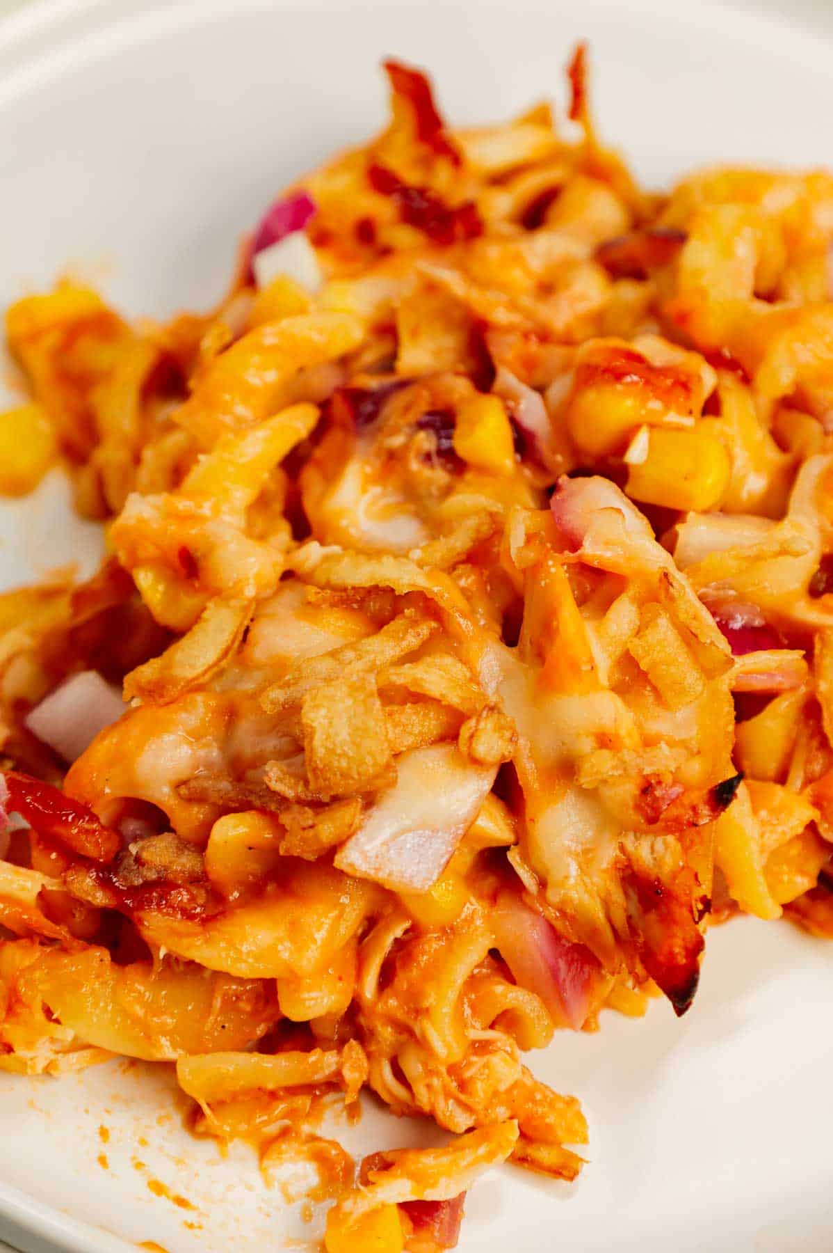 BBQ Chicken Casserole is a hearty dish loaded with egg noodles, shredded rotisserie chicken, diced red onions, corn, cream of chicken soup, barbecue sauce, cheese and French's crispy fried onions.