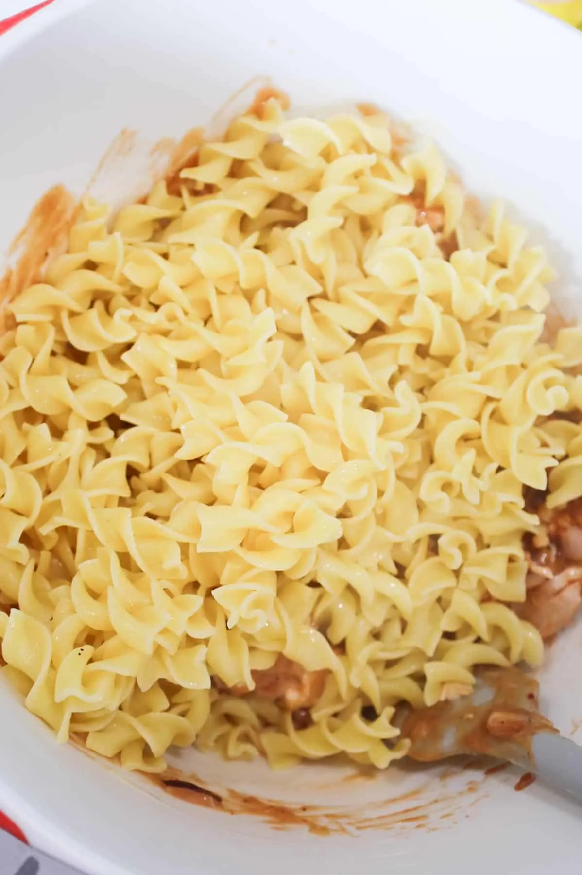 cooked egg noodles added to bowl with bbq chicken mixture