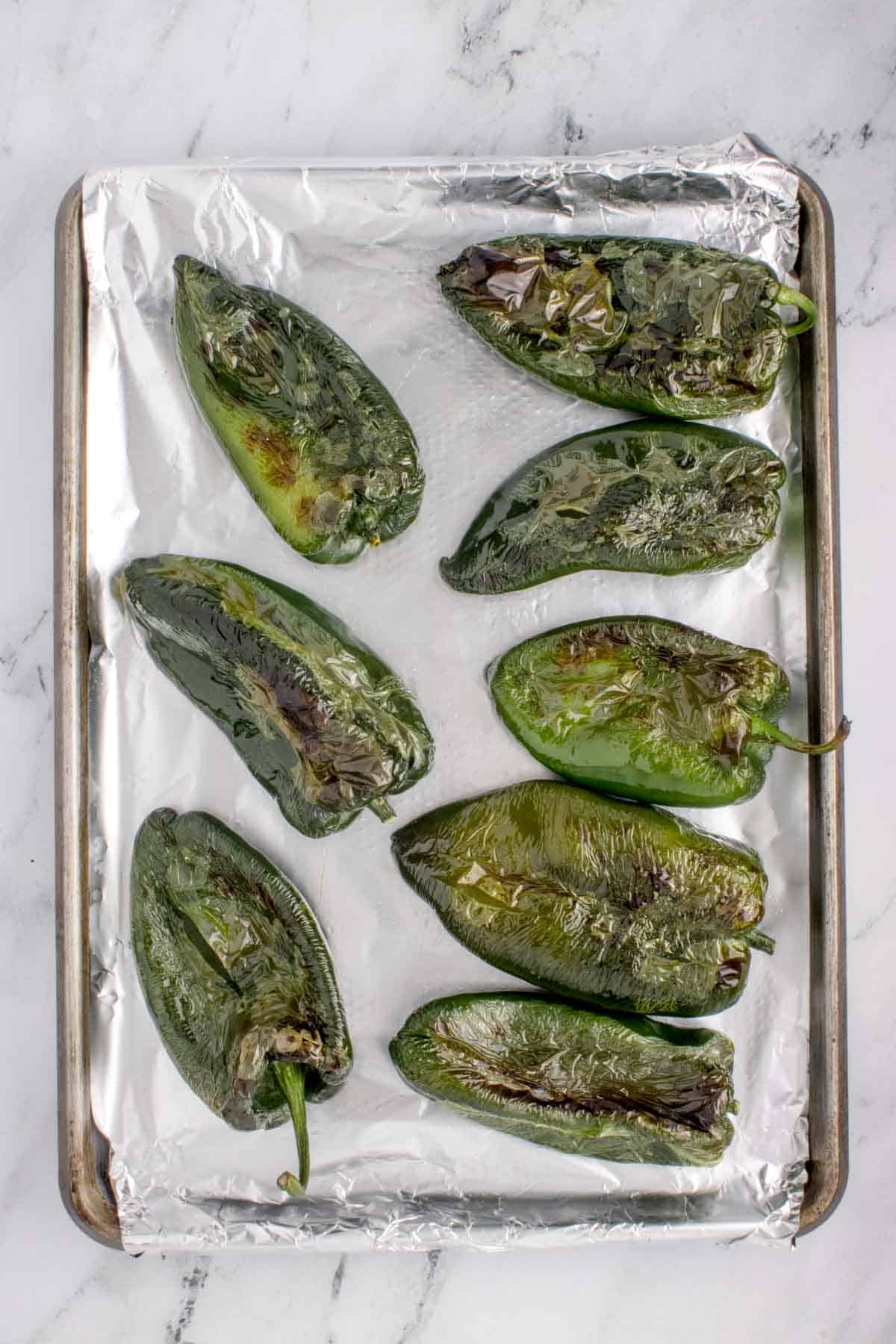 roasted poblano peppers on a baking sheet