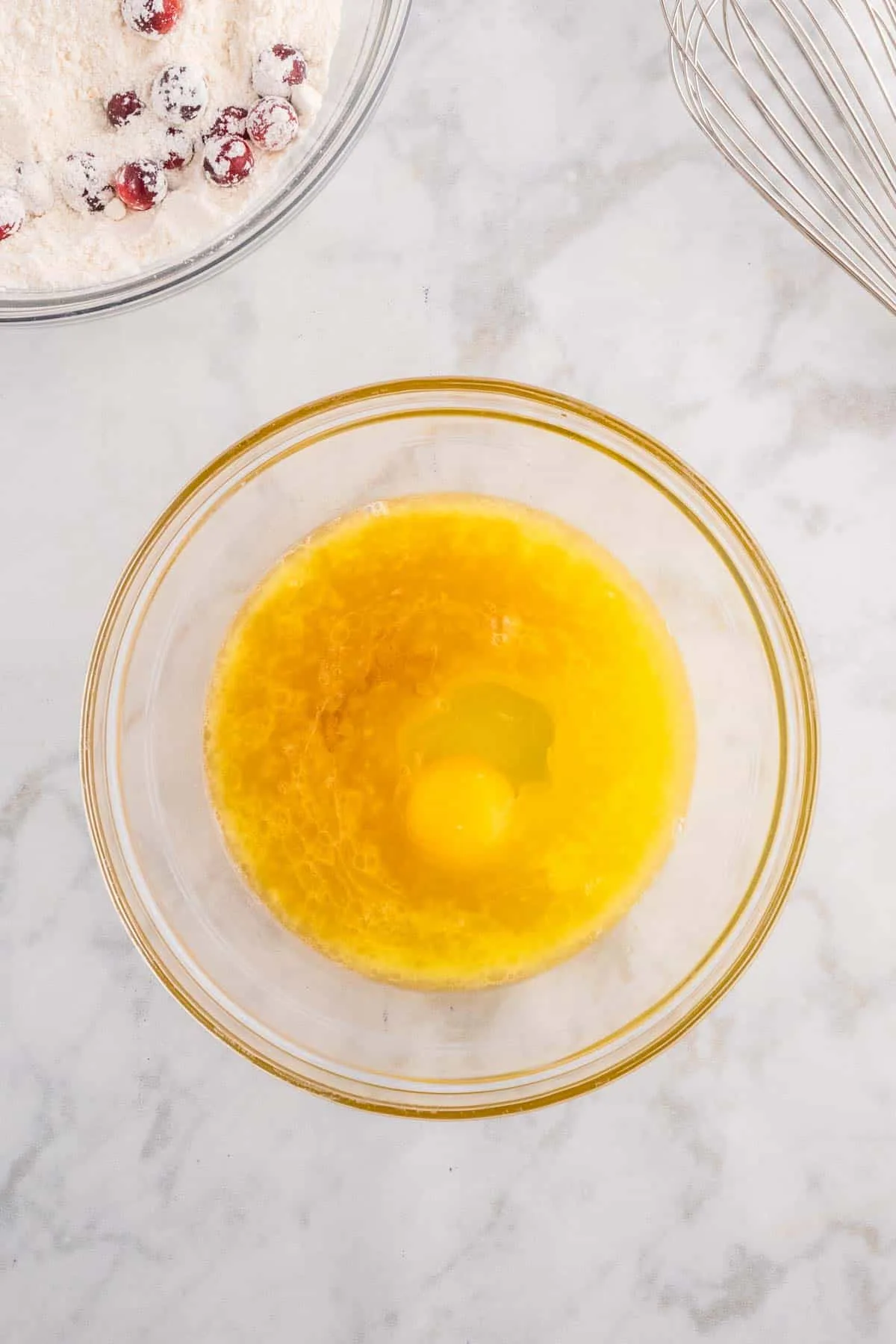 melted butter, orange juice, vanilla extract and an egg in a mixing bowl