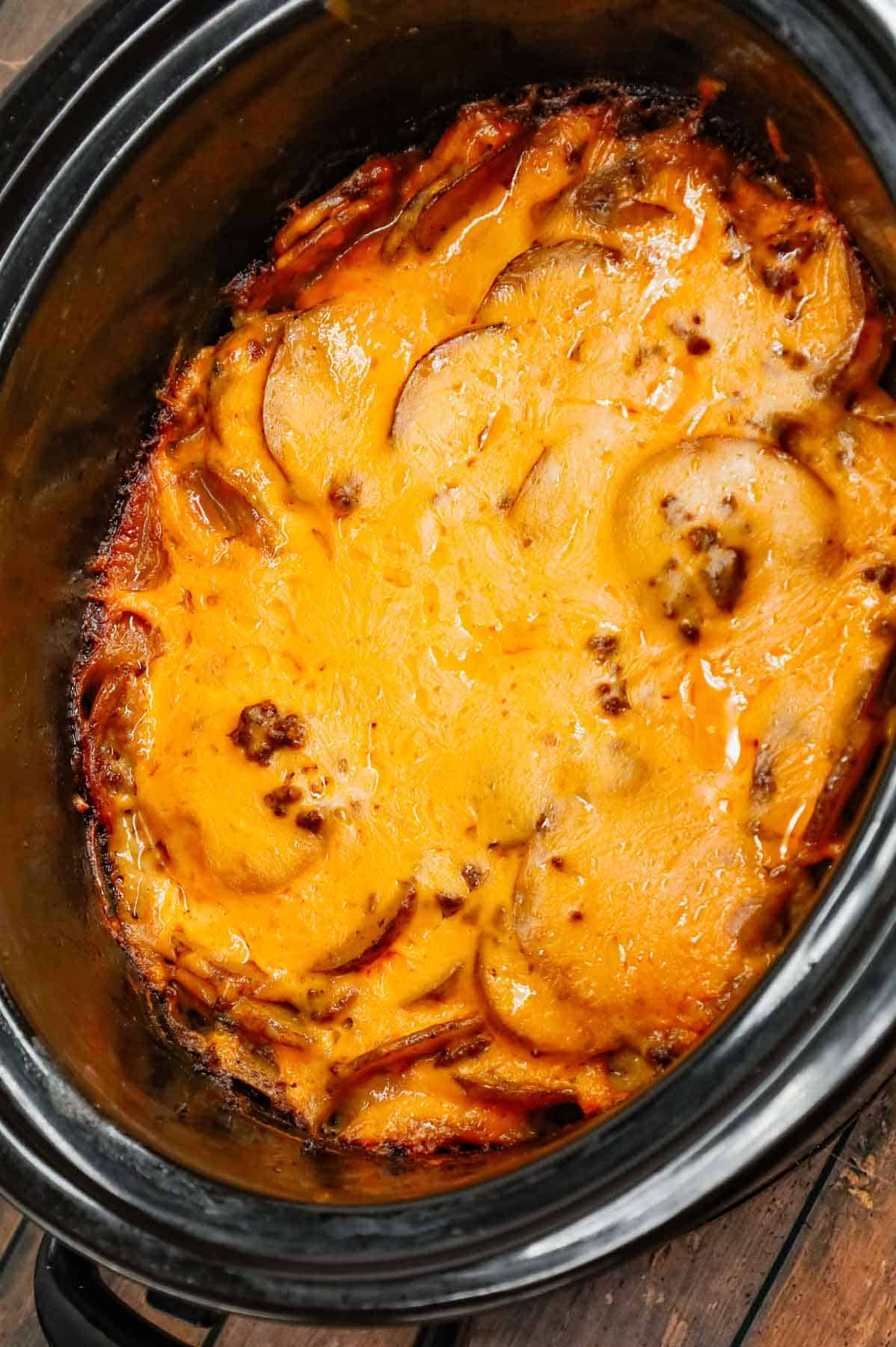 Crock Pot Hamburger Potato Casserole is a hearty slow cooker dinner loaded with ground beef, sliced potatoes, sliced onions, cheddar soup, cream of mushroom soup and shredded cheddar cheese.