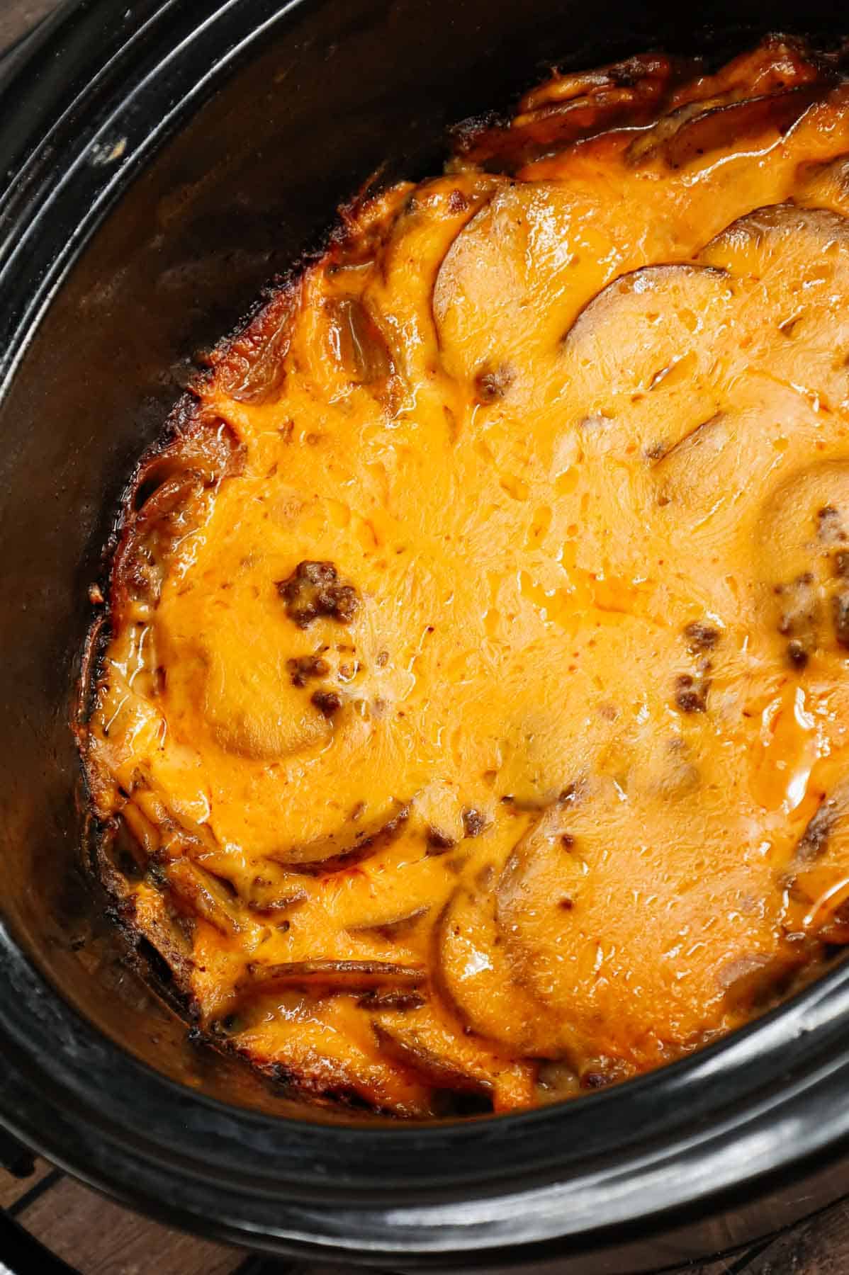 Crock Pot Hamburger Potato Casserole is a hearty slow cooker dinner loaded with ground beef, sliced potatoes, sliced onions, cheddar soup, cream of mushroom soup and shredded cheddar cheese.