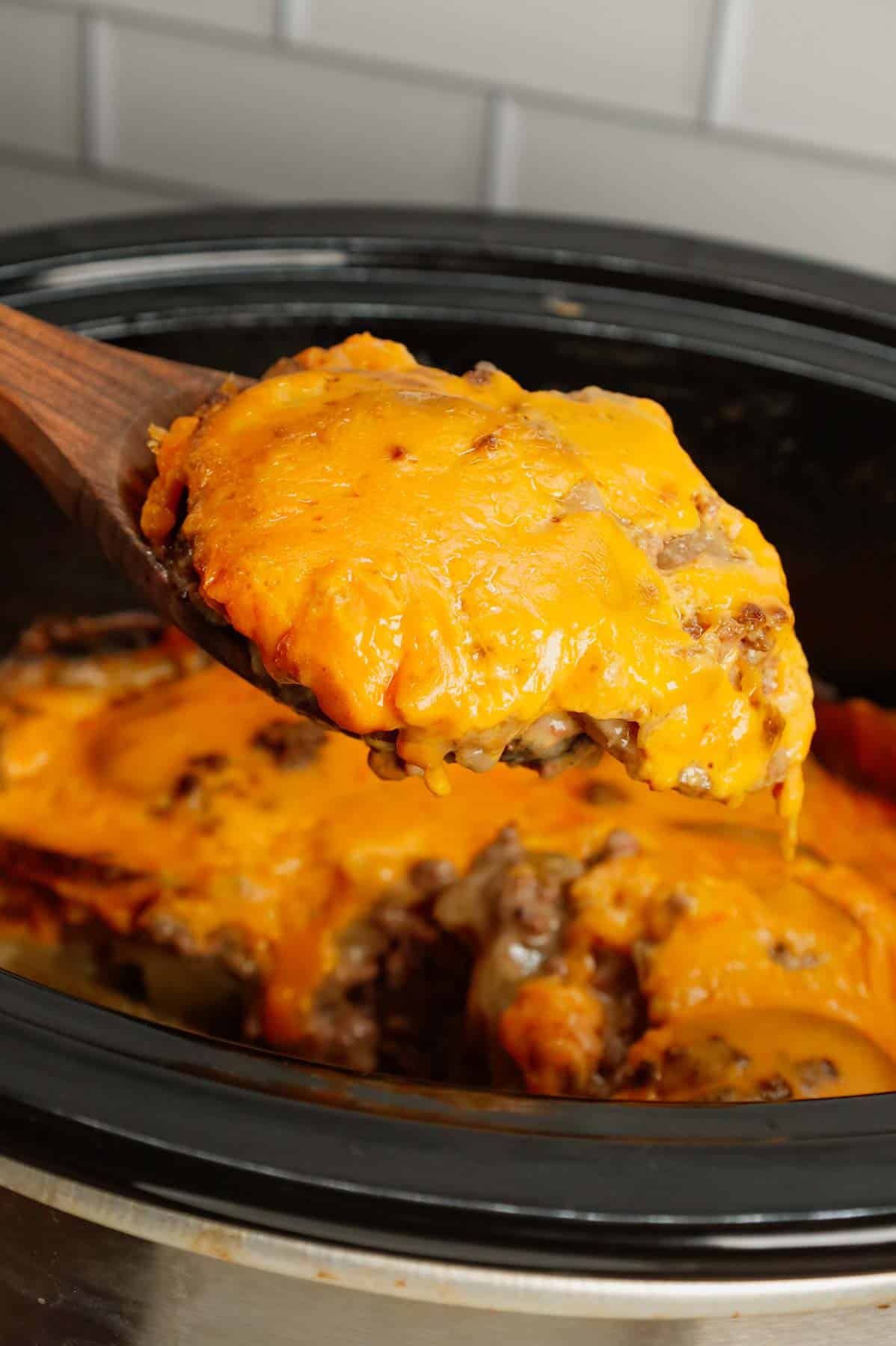 Crock Pot Hamburger Potato Casserole is a hearty slow cooker dinner loaded with ground beef, sliced potatoes, sliced onions, cheddar soup, cream of mushroom soup and shredded cheddar cheese.