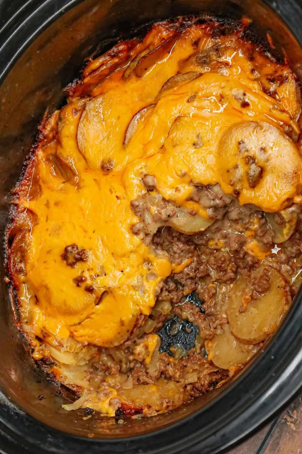 Crock Pot Hamburger Potato Casserole is a hearty slow cooker dinner loaded with ground beef, sliced potatoes, sliced onions, cheddar soup, cream of mushroom soup and shredded cheddar cheese.