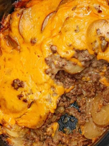 Crock Pot Hamburger Potato Casserole is a hearty slow cooker dinner loaded with ground beef, sliced potatoes, sliced onions, cheddar soup, cream of mushroom soup and shredded cheddar cheese.