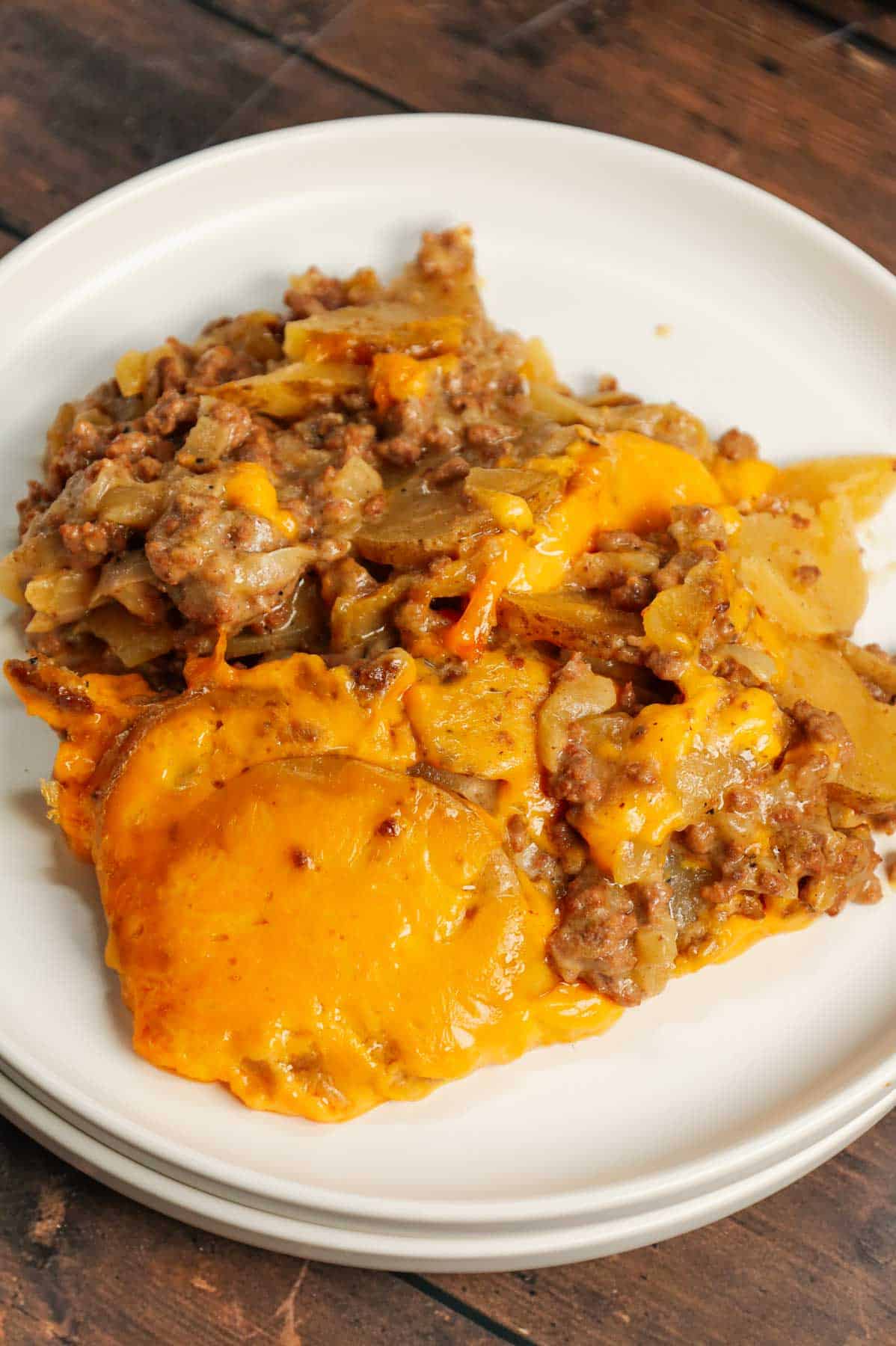 Crock Pot Hamburger Potato Casserole is a hearty slow cooker dinner loaded with ground beef, sliced potatoes, sliced onions, cheddar soup, cream of mushroom soup and shredded cheddar cheese.