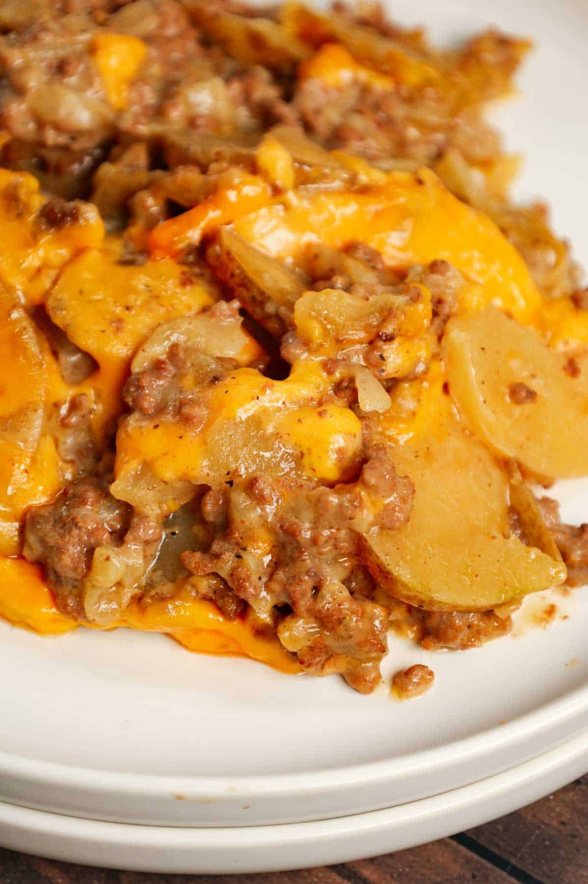 Crock Pot Hamburger Potato Casserole is a hearty slow cooker dinner loaded with ground beef, sliced potatoes, sliced onions, cheddar soup, cream of mushroom soup and shredded cheddar cheese.