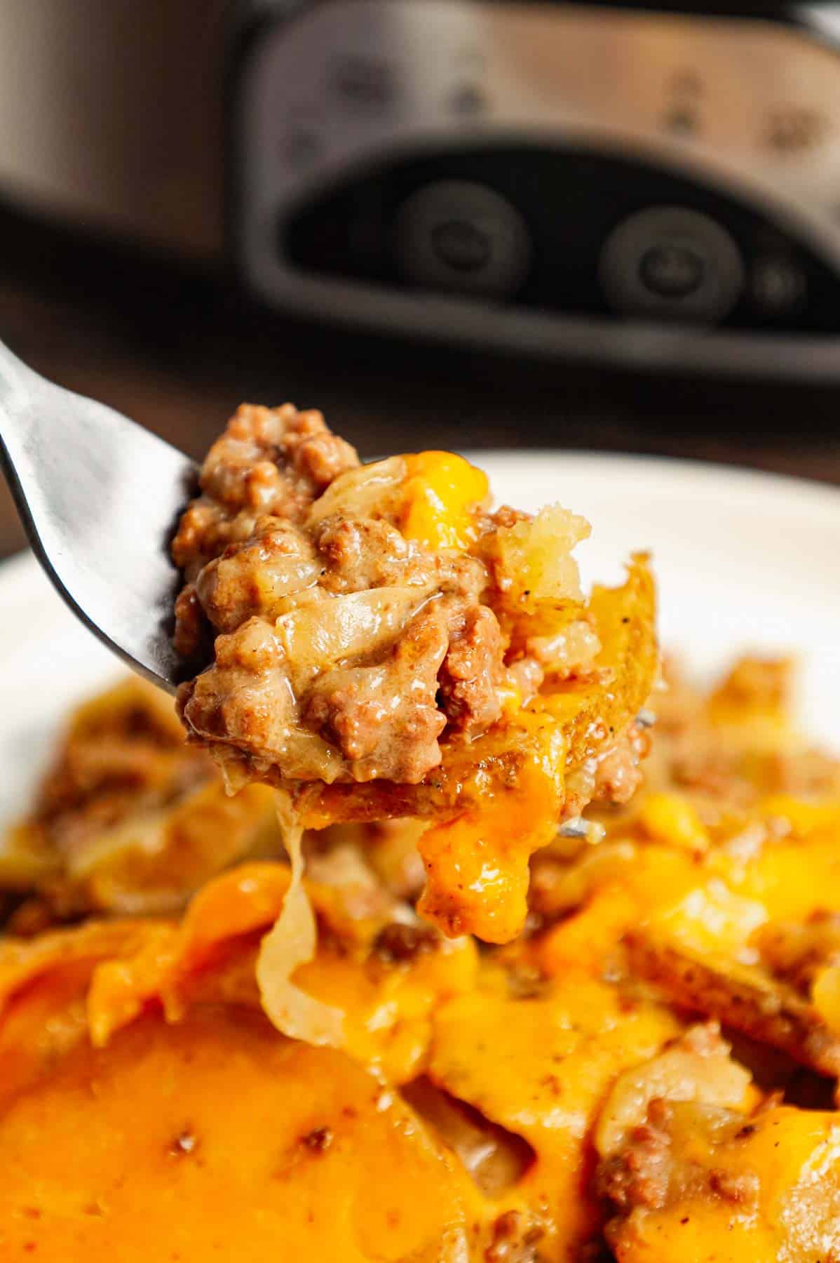 Crock Pot Hamburger Potato Casserole is a hearty slow cooker dinner loaded with ground beef, sliced potatoes, sliced onions, cheddar soup, cream of mushroom soup and shredded cheddar cheese.