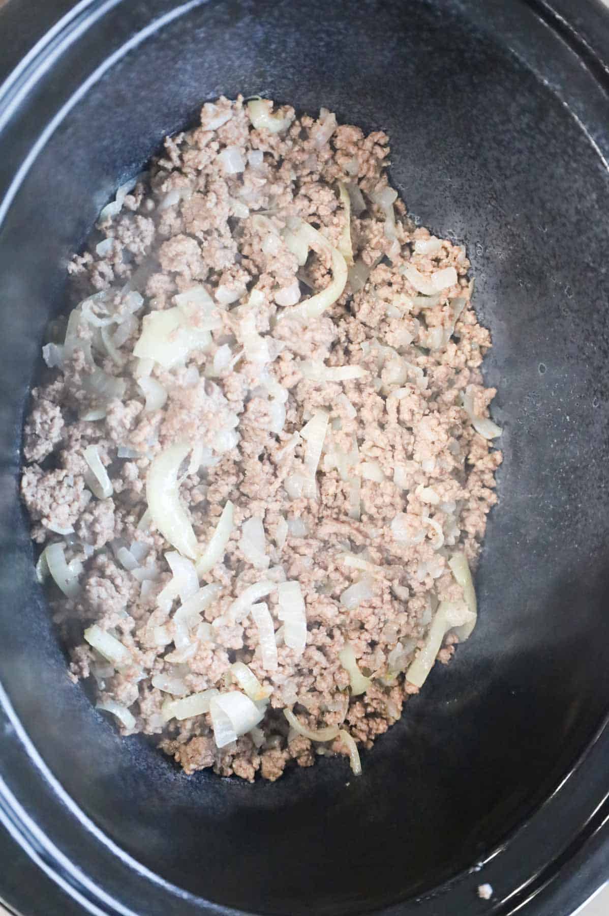 cooked ground beef and onions in a Crock Pot