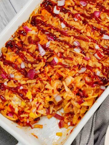 BBQ Chicken Casserole is a hearty dish loaded with egg noodles, shredded rotisserie chicken, diced red onions, corn, cream of chicken soup, barbecue sauce, cheese and French's crispy fried onions.