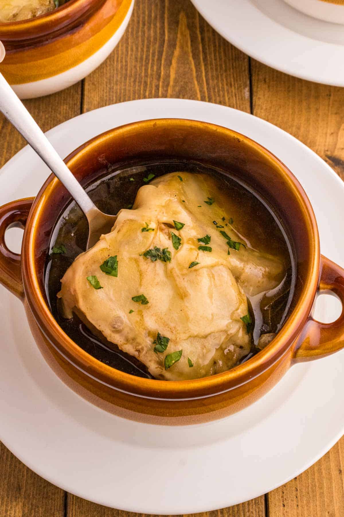 Easy French Onion Soup is a delicious soup with a beef broth base loaded with caramelized onions and topped with baked slices of French baguette and melted Gruyere or Swiss cheese.