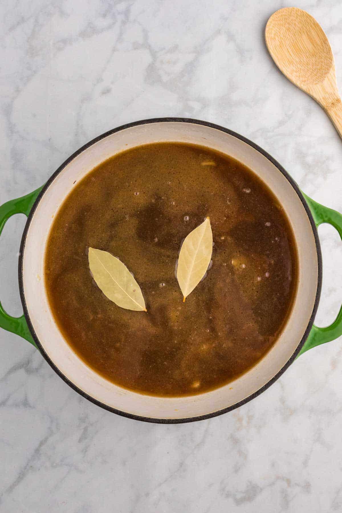 bay leaves and beef broth in a pot