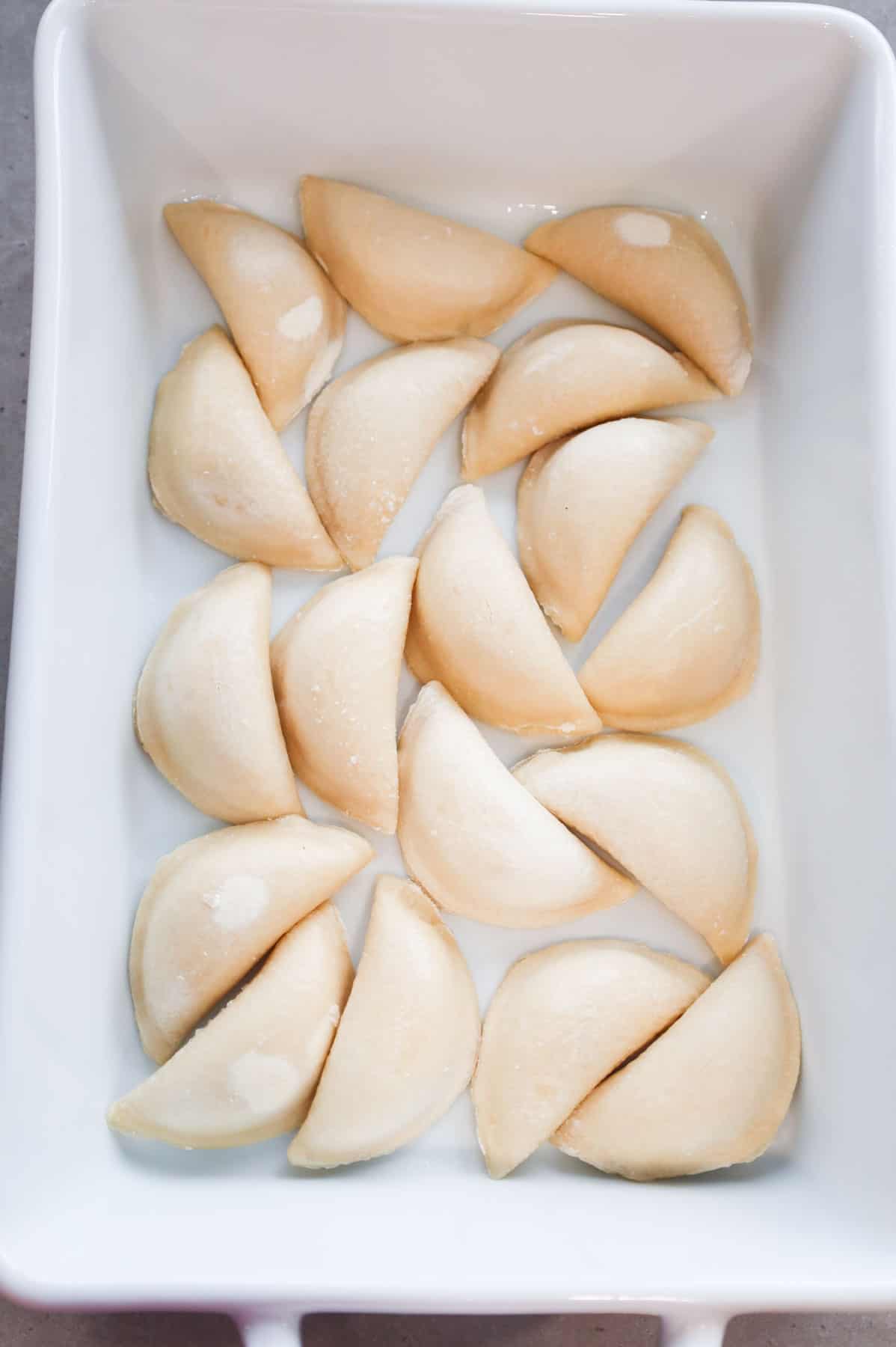 frozen pierogies in a baking dish