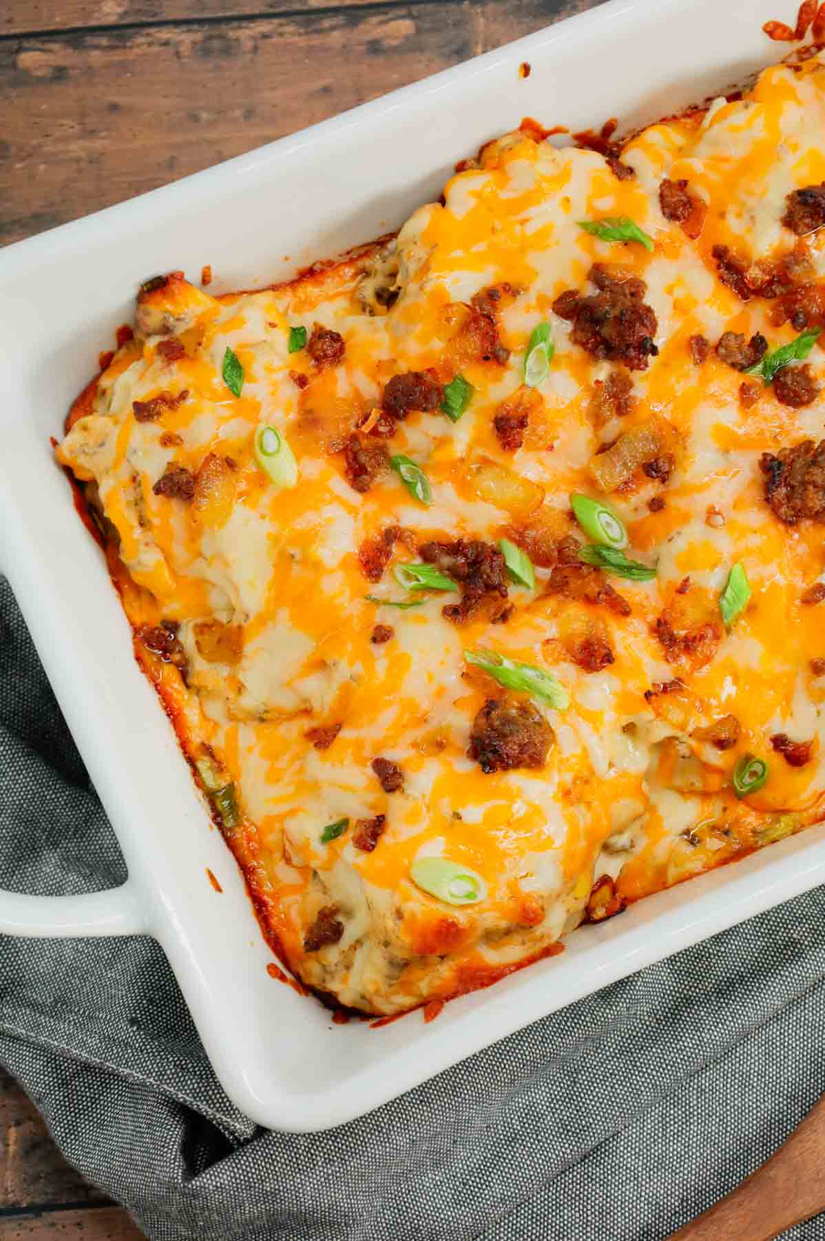 Pierogi Casserole is a hearty dinner recipe loaded with crumbled Italian sausage, onions, three cheese pierogies, cream cheese, Alfredo sauce, shredded mozzarella and cheddar cheese.